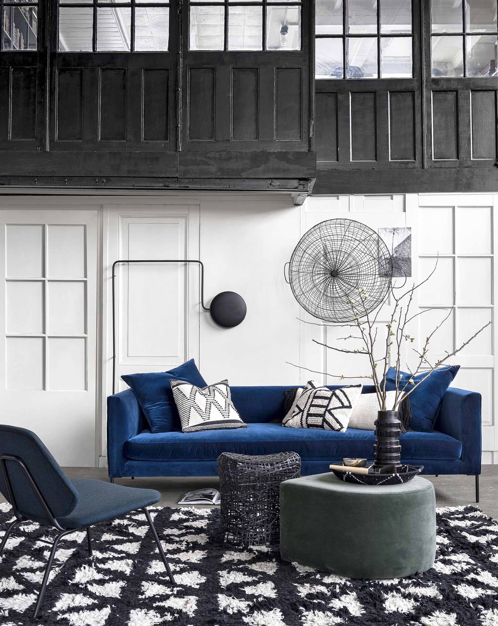 Fluwelen bank van Wendelbo, poef van Aytm (Goeds). Fauteuil van Woud, lamp van Woud (Eijerkamp). Karpet Mekong Nights van wol en katoen (AAI made with love). Kruk van draadstaal, grote draadmand (Pols Potten). Kussens met geometrische patronen, kommetje, vaas (HKliving). Langwerpig kussen met franje (Ksähar). Gevlochten mandje (Household Hardware).