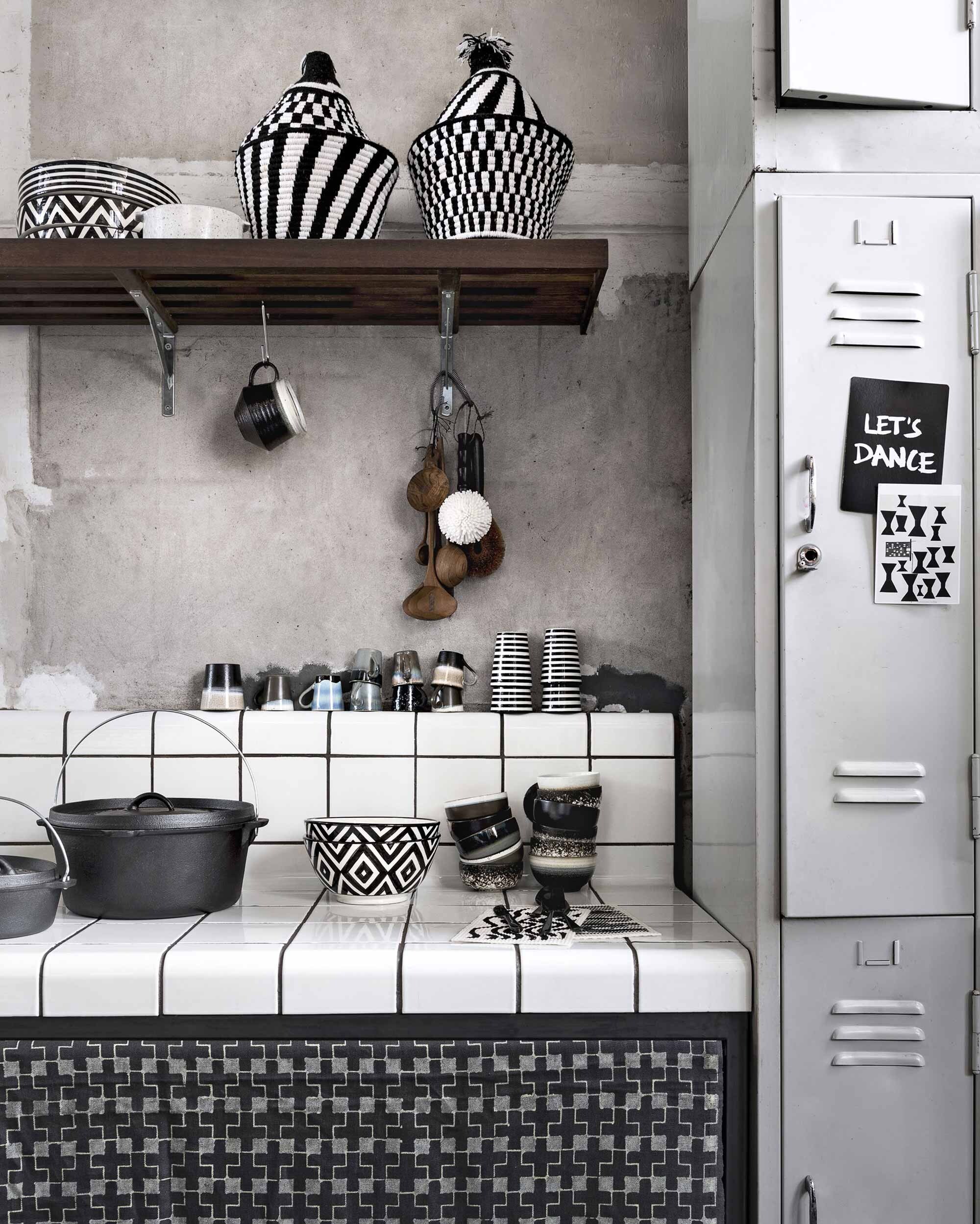 Tegels van Droog Design prijs op aanvraag (Dtile). Gordijn van handbedrukte stof (Charlene Mullen). Gietijzeren pannen van Dutch Oven (200° Fahrenheit). Zwart-witte schalen van keramiek, gestreepte mok, gevlochten pot met deksel (Household Hardware). Keramisch ovenschaaltje met handvatten, kommen, espressokopjes, teakhouten lepels, afwasborstels (HKliving). Schoonmaakdoekjes van Ferm Living met print (Kolk en Kolk). Bestek van vtwonen (vtwonen.nl). Lockerkasten (Van Dijk &amp; Ko). Ansichtkaart (ArtUnlimited). Kaart met tekst uit Get of the internet van Bis Publishers.nl met kreten uit de popmuziek (Popmusicwisdom). Kom met oor privébezit.