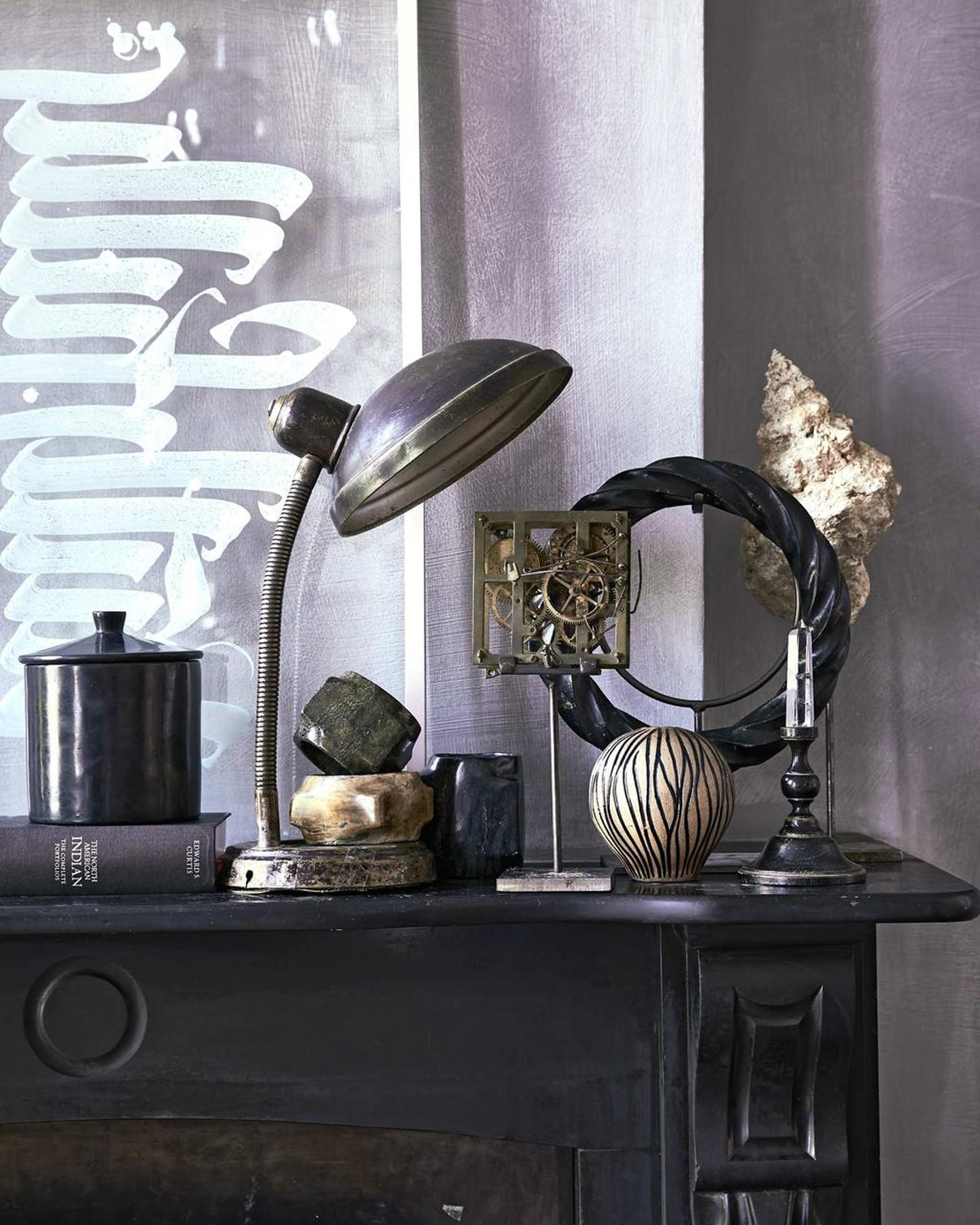 Stenen armbanden bruin, groen, bovenste, metalen ornament op voet, zwarte ring op voet, kristal op voet, schelp op voet (The Wunderkammer). Zwarte pot, kleine vaas (MaisonNL). Vintage lamp (De Weldaad). Overig privébezit.