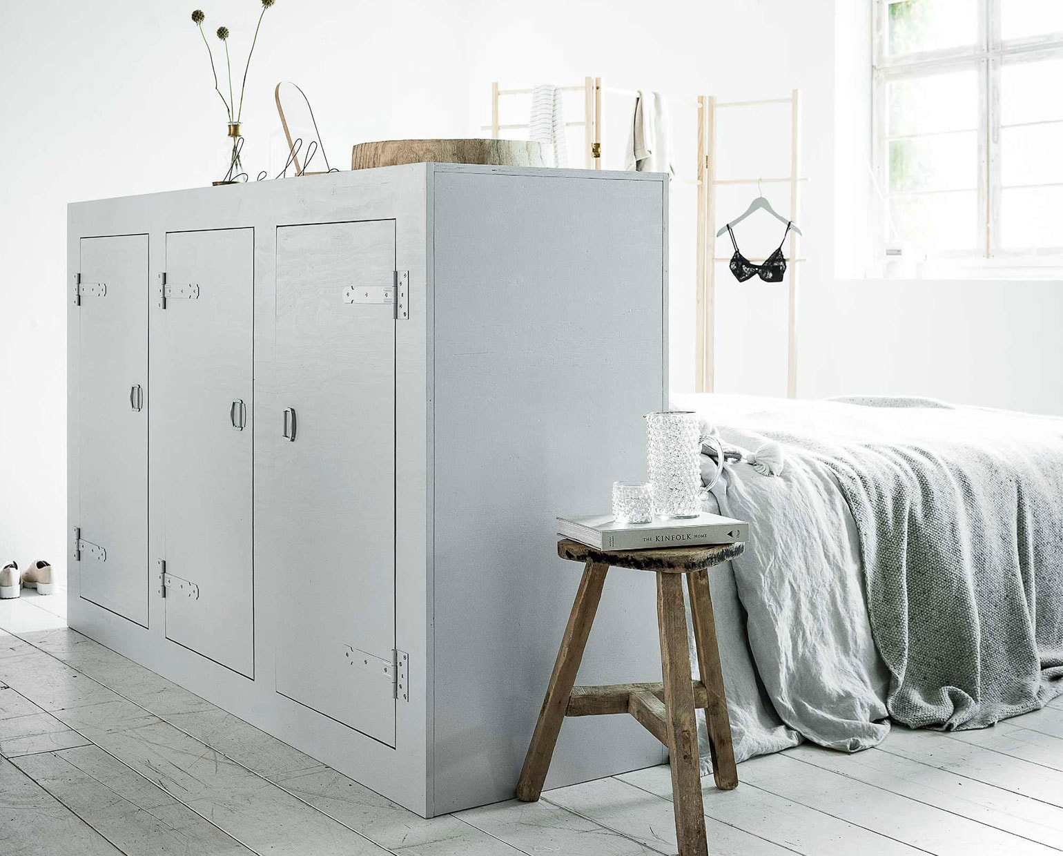 De achterwand is geschilderd in kleur Skylight No. 205 Farrow &amp; Ball. Vaas met gouden rand van Nordal, letters Hello in zwart ijzerdraad Yaya Home, dekbedovertrek House in Style, plaid House in Style, kussen met kwastjes van Tine K Home. Glazen apothekersfles Burbri Antiek. Juwelendoos Menu, kledingrek Nomess Copenhagen via vtwonen. Grote houten schaal, houten kruk Het Kabinet. Zwarte beha H&amp;M. Overig privébezit.