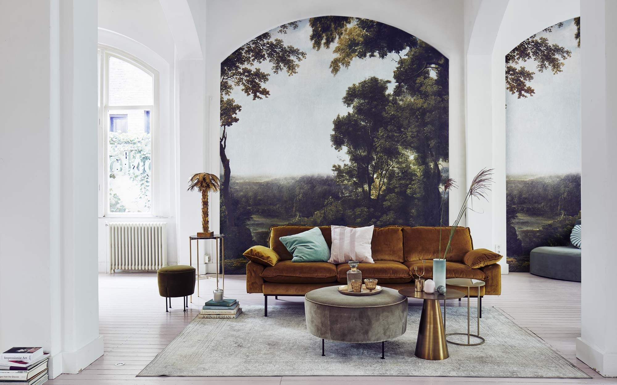 Behang Collaboration Tres Tintas M2600-1 van Rebel Walls (). Vloerkleed Rugged light van Dutchbone (). Okergele fluwelen bank, ronde gouden tafel, palm lamp (). Grote ronde fluwelen poef van Gubi, kleine mosgroene poef van Gubi (). Hoge bijzettafel met gouden frame en marmeren blad (). Kleine bijzettafels met emaillen blad, set van 2 (). Whiskyfles, gouden kandelaar (). Lichtgroene fluwelen kussenhoes, oudroze glas op voet en glas (). Roze kussen Sanati van fluweel met strepen (). Mint-wit rond kussen Circus (). Halfronde fluwelen bank Home Pouf with backrest van Tine K Home (). Roze vaasje Gradvis set van 2 (). Karaf/vaas ().