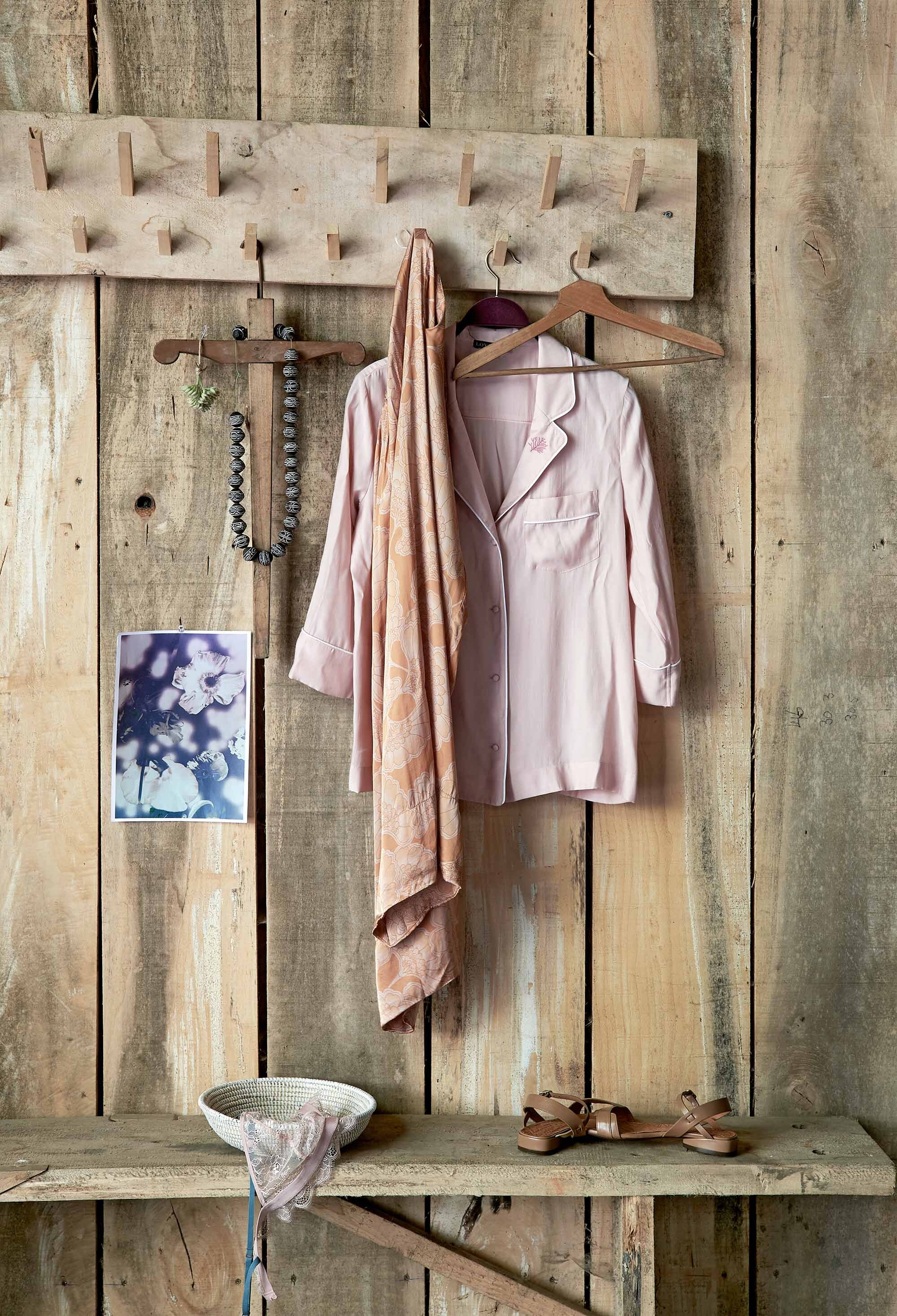 Broek, pyjama-look blouse van Love Stories, kanten beha van Love Stories, sandalen (MaisonNL). Ketting van keramiek uit Kenia (Couleur Locale). Rietenschaaltje (Household Hardware). Oude houten hangers (Burbri Antiek). Print (Hedwig van Onna). Soortgelijke kapstok en houten bank (Combitex).