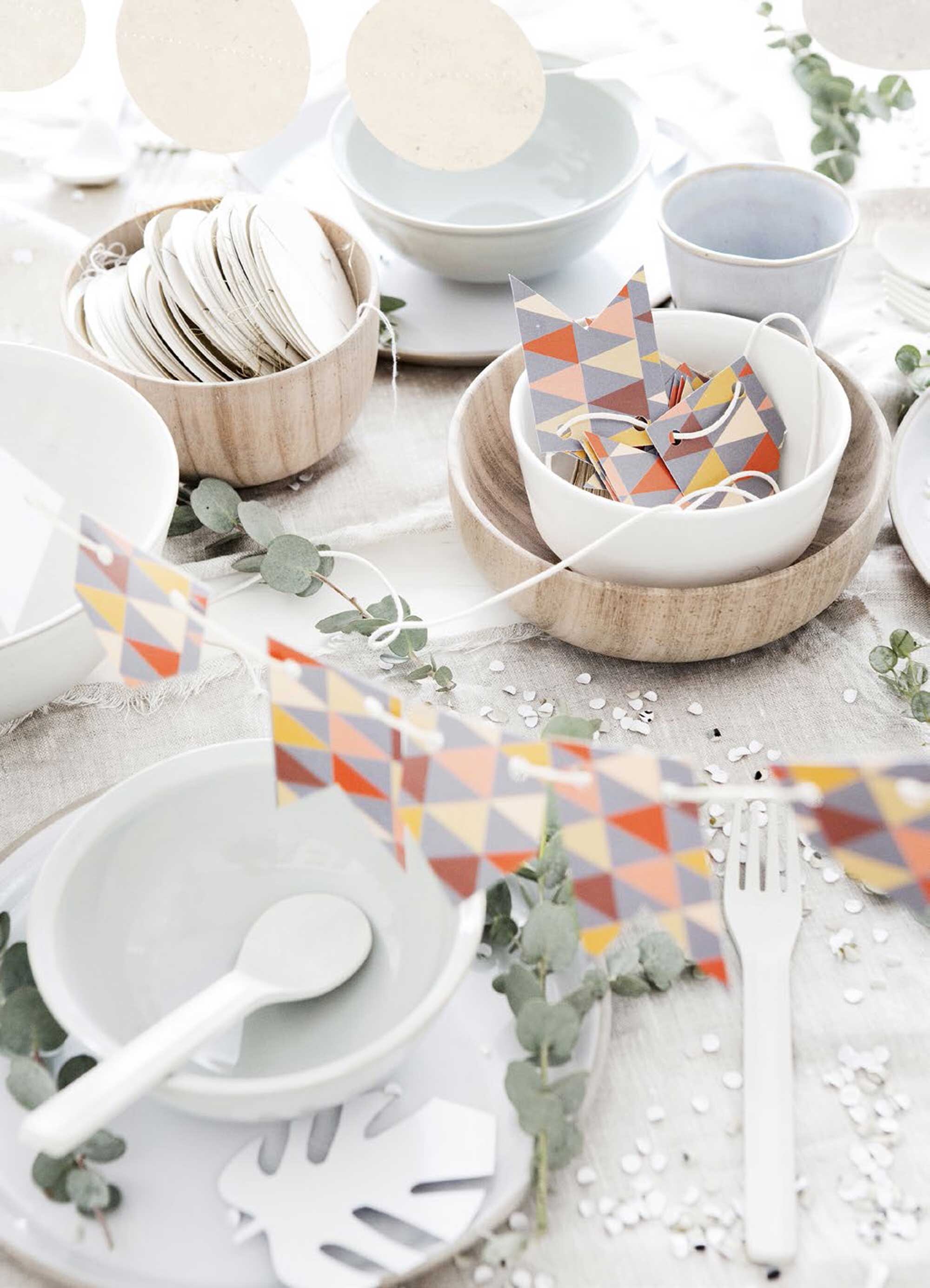 Deze vrolijke vlaggetjesslinger maak je met de pagina uit het posterboek. En ook de confetti maak je zelf met het confettiblad. Houten schaaltje van HK Living klein, groot, bruin-wit bord (www.vtwonen.nl). Witte slinger set van 4, lichtblauwe mok (Sukha Amsterdam). Lichtblauw schaaltje, bestek (Six and Sons). Overig privébezit.