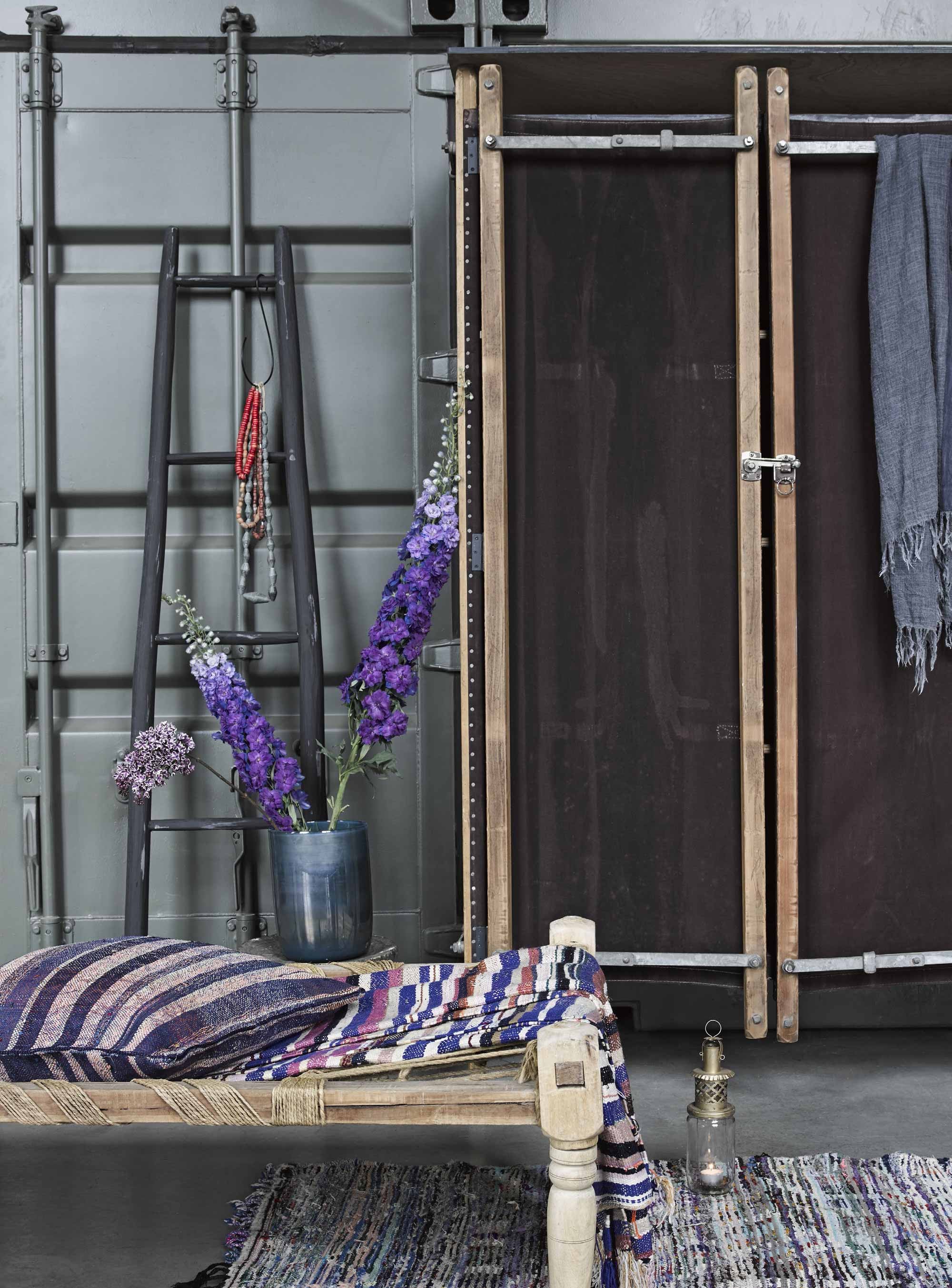 Kast gemaakt van Zwitserse brancards (). Geweven streepkussen, gestreepte doek, windlicht van jampot, vloerkleed, trap (). Blauwglazen vaas (). Kettingen van glas (). Sjaal (). Indiaas daybed privébezit, soortgelijke te koop bij . Overig privébezit.