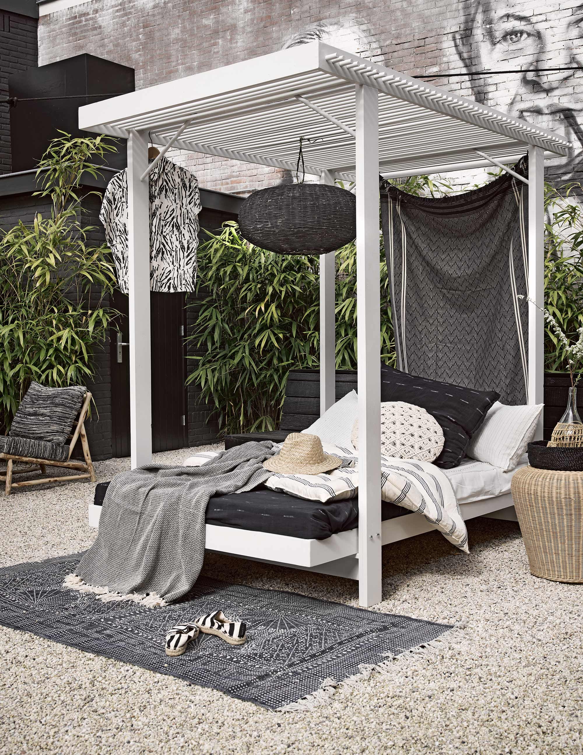 Hemelbed (). Vloerkleed, donker kussen, gestreept matras, donkere doek, wit gestreepte kussens, houten fauteuil met zwarte bekleding, fles (). Rieten bijzettafel (). Zwarte rieten lamp (). Bloesje (). Zwarte hamamdoek, hoed en zwart-wit gemêleerde plaid (). Rond gehaakt kussentje ().