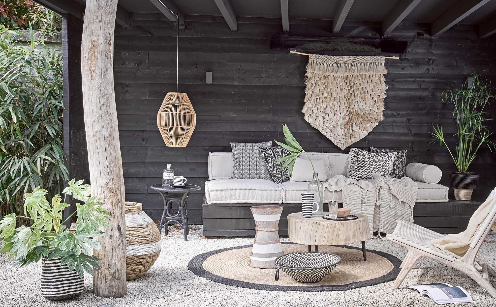 Loungekussens, rugkussen, rolkussenhoes, ecru kussen (). Wandkleed, houten buitenstoel, hoge gevlochten pot met witte band, houten bijzettafel met witte bies, grote houten tafel, lage schaal in zwart-wit, hanglamp, zwart-wit gestreepte mand, gevlochten pot met zwarte rand, ecru plaid Kaldi op stoel (). Gebreide deken, vloerkleed rond (). Emaillen dienblad (). Hoge gestreepte kan, gestreepte beker (). Houten kom (). Glas (). Oude apothekersfles (). Glazen fles (). Zwarte bijzettafel (). Gedessineerde kussenhoes links, kussenhoes met zwarte bladeren, kussenhoes met rafels en grafisch dessin, zwarte kussenhoes met witte blaadjes ().