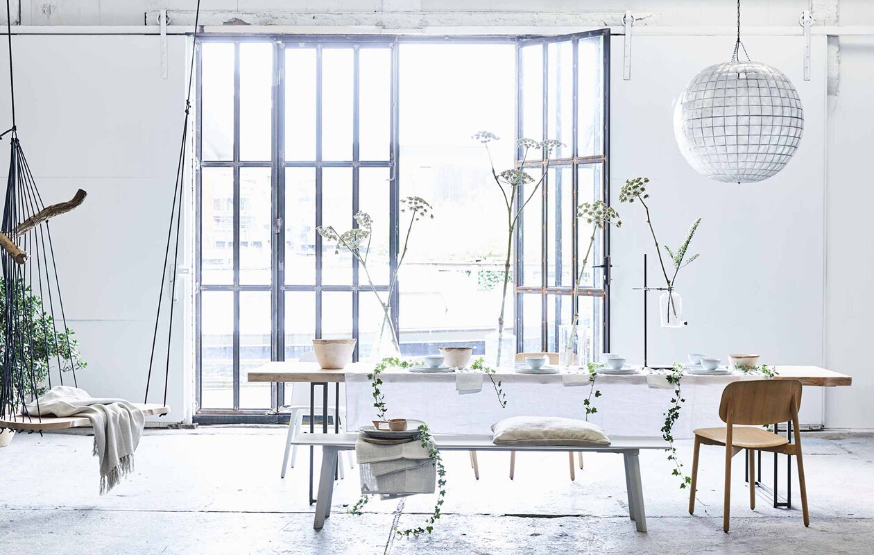 Tafelkleed in optic white, servetten, hoge houten schaal, houten bekers met oor (Couleur Locale). XL bollamp van schelpen, grote witte borden, kleine borden, kommen, houten schaal, keramische schaal op bank (HK Living). 24-delig bestek Behagfull (Ikea). Labflessen divers, lab standaard (Neef Louis). Eettafel Altar van Jesse Sanderson, hangstoel Floating divan van Chiel Kuijl (Wdstck). Grijze bank Copenhague Deux Bench, houten stoelen Soft Edge (Hay Amsterdam). Witte stoel Nerd van Muuto (Design 020). Plaid in stoel, kussen (De Weldaad). Linnen laken op de bank van No.6 (My Deer’s). Overig privébezit. vtwonen 2017-07 | Fotografie Jeroen van der Spek | Styling Cleo Scheulderman