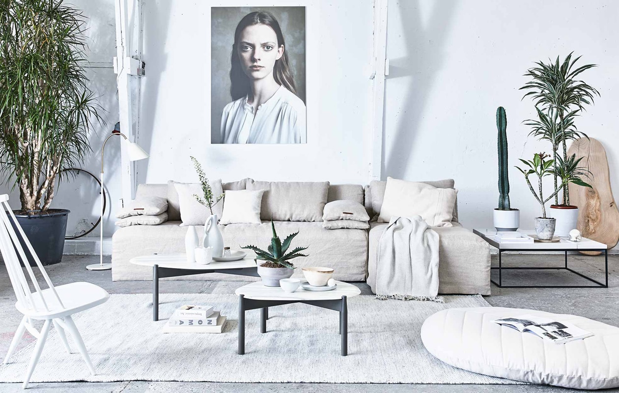 3-zits bank Michelle met loungegedeelte, chaise longue, losse rugkussens, (L’Authentique). Lamp Bellevue van &amp;Tradition, witte stoel Mademoiselle van Artek (Mobilia). Vloerkleed Ply van Muuto, ecru kussen van Muuto links (Design 020). Bijzettafels Heat met marmeren blad, vierkante salontafel Terrace loud white (Linteloo). Foto op de muur Iris van Maarten Schröder (Wdstck). Grijze plantenpot (Homestede). Witte keramische plantenpot (My Deer’s). Wit kommetje, bordje van keramiek, houten platte schaal (HK Living). Hoge houten schaal, wit alpaca wollen kussen (Couleur Locale). Kussen ecru, plaid (De Weldaad). Poef Dimhult, glazen schaal met plant afkomstig uit een set van 3 uit de Ikea PS 2017 collectie (Ikea). Vaas links op de tafel (CK Ceramics). Overig privébezit. vtwonen 2017-07 | Fotografie Jeroen van der Spek | Styling Cleo Scheulderman