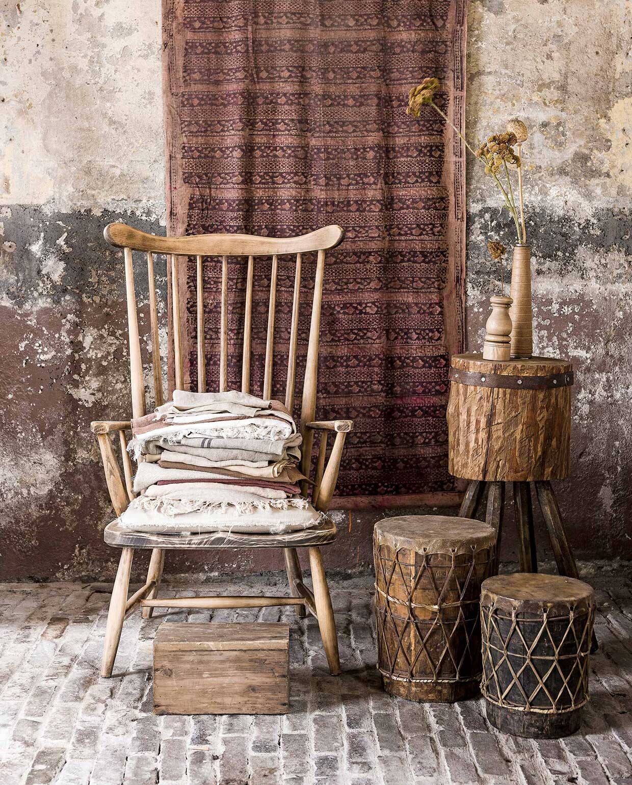 Oude houten spijlenstoel (Kringkoop). Linnen lapjes en theedoeken vanaf (). Linnen stof bruin per meter (). Wandkleed, hakblok (). Trommels (). vtwonen 06-2017 | Fotografie Sjoerd Eickmans | Styling Liza Wassenaar, Leonie Mooren