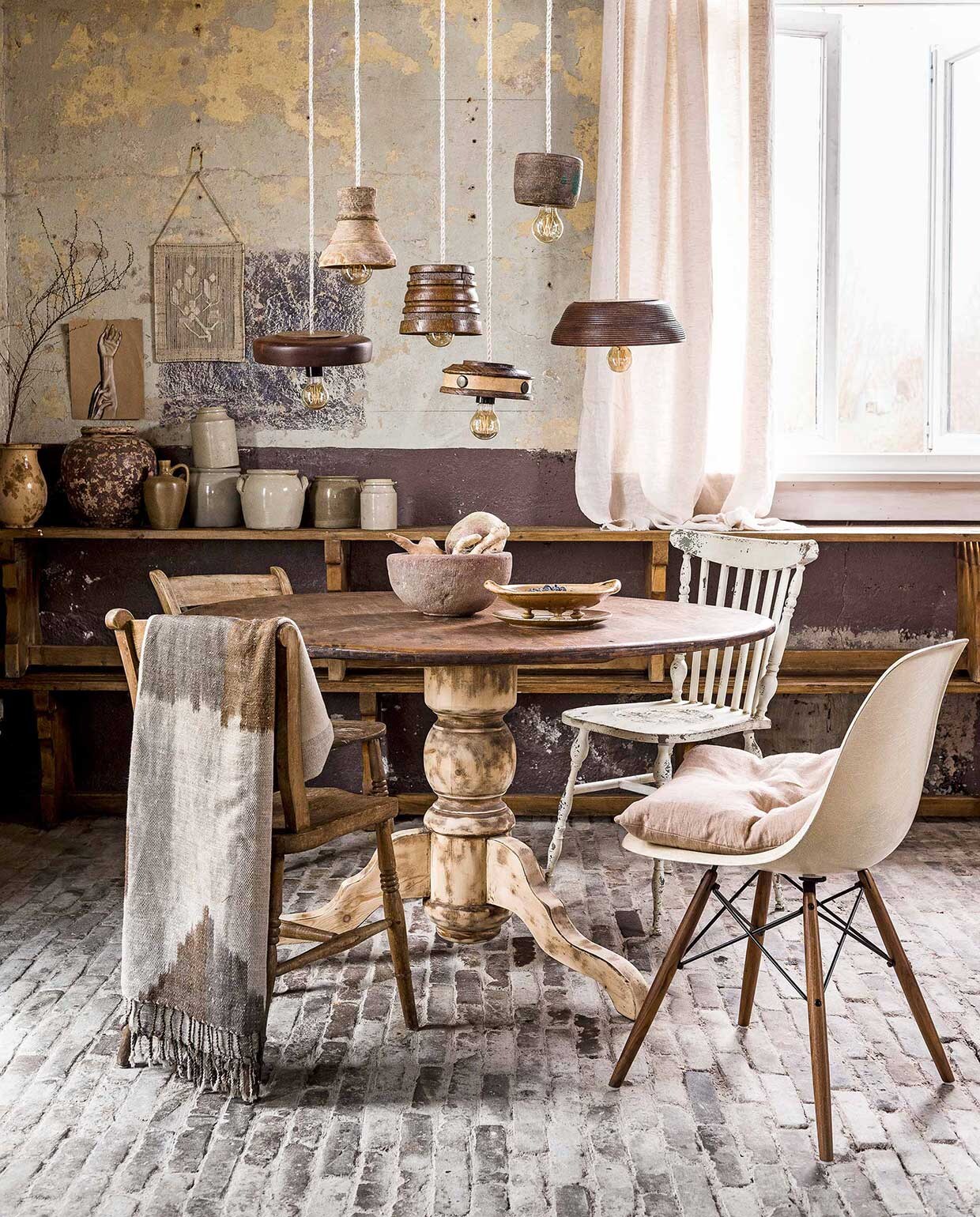 Schaaltjes, kunstwerkje met touw (). Linnen strijkijzersnoer, fitting van zwart bakeliet, kooldraadpeer dimbaar (). Tafelpoot geschuurd (). Stenen schaal, gevlekte karaf (). Fruitschaal/zeef, kleine karaf, wekpotten (Linda’s Hoekje). Vergeten groente (). Stoel Eames (). Kussen, gordijn gemaakt van linnen stof (By Mölle via ). Houten stoelen, twee houten bankjes op elkaar gestapeld als kast, grote karaf (met tak) (). Witte spijlenstoel (). Sjaal op stoel (). Kunstwerkje handen (Julia Lefeber). vtwonen 06-2017 | Fotografie Sjoerd Eickmans | Styling Liza Wassenaar, Leonie Mooren