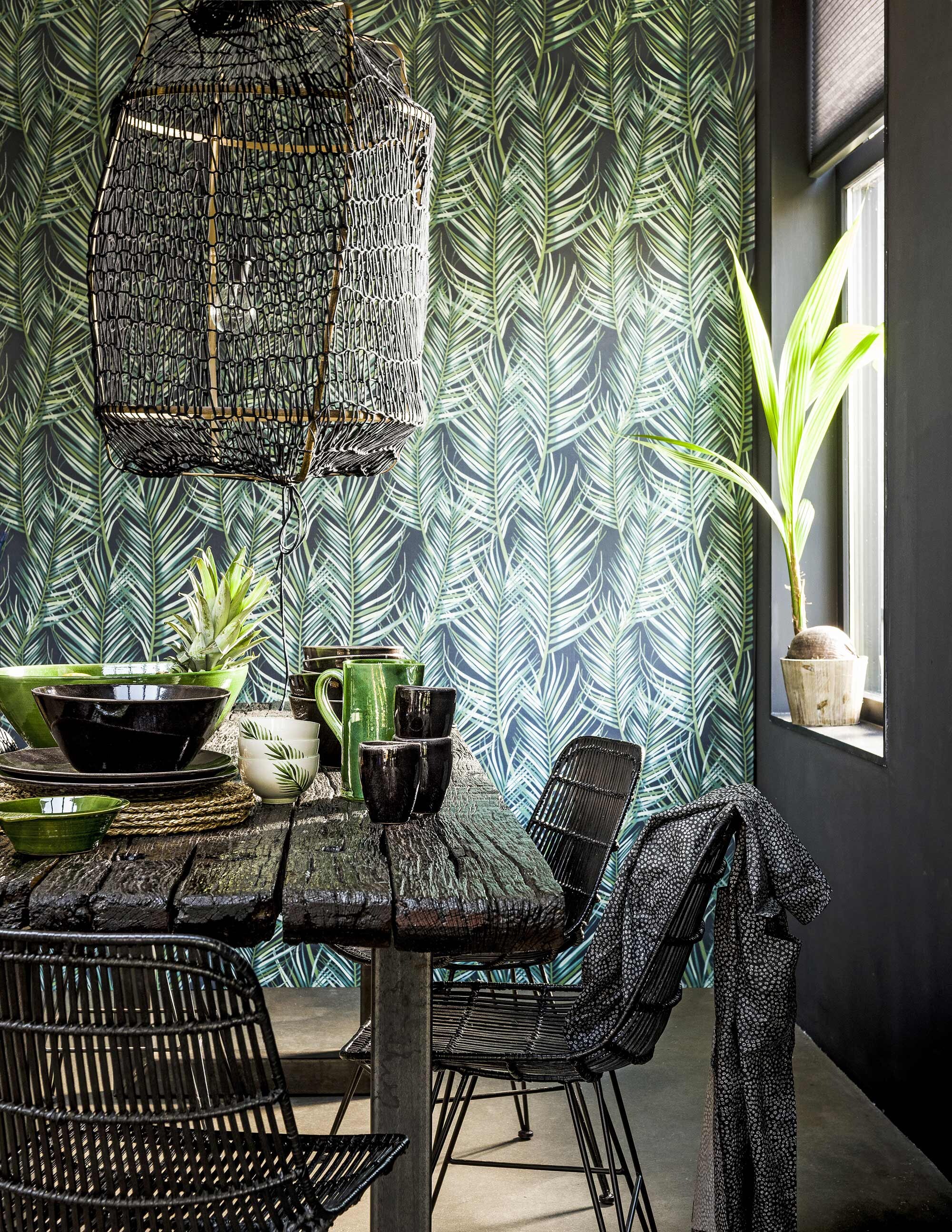 Behang Palm Leaf (). Ay illuminate lamp (). Zwarte rotanstoelen (). Kimono (). Grote groene schaal, XL, groene karaf, klein oudgroen schaaltje S (). Zwarte mokken Nordic, zwarte borden Nordic, grote zwarte schaal Nordic, kleinere zwarte schalen Nordic, kommen Nordic, schaaltjes met palmblaadje (). Sisal placemats Ihållig (). Kokospalmpje (tuincentrum, ). Tafel privébezit.