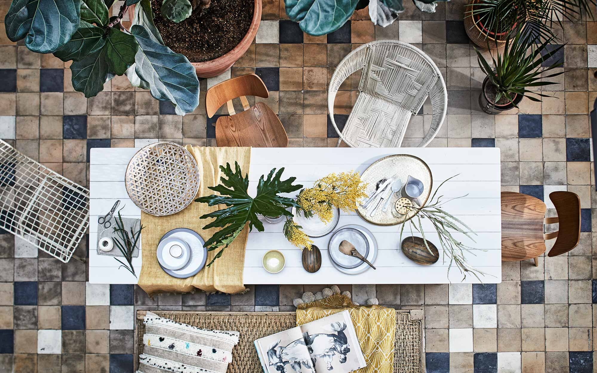 Tafel (). Bank, witte metalen stoel (). Okergele doek op tafel, mand met pompons (). Gele kom (). Gouden dienblad, hoornen schaaltjes (). Borden met opstaande rand klein en groot, kom met opstaande rand, kan, vazen met gouden deksel (). Bestek van knIndustrie (). Soortgelijke oude tegels (). Gevlochten schaal (). Overig privébezit.
