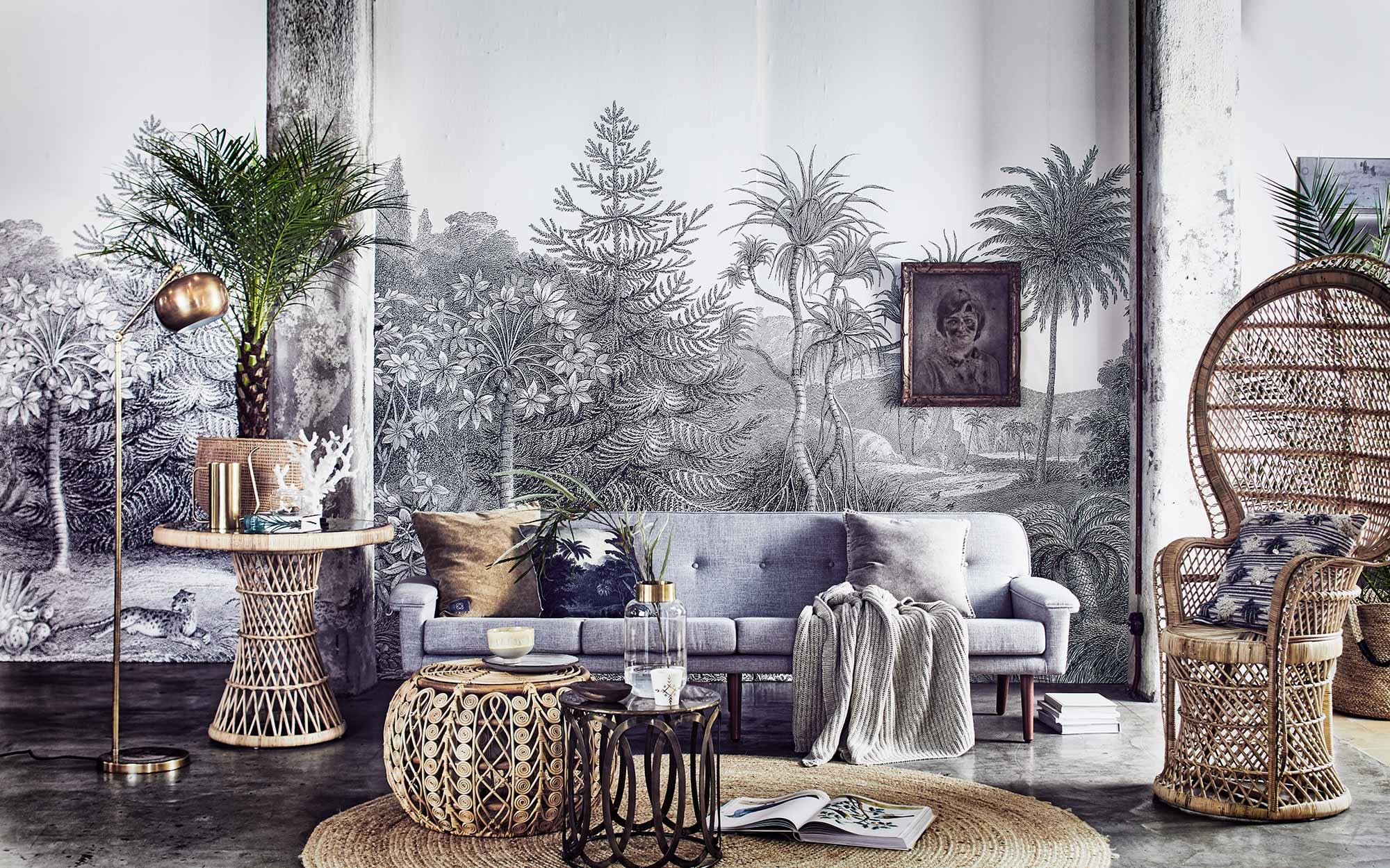 Behang Jungle Lands Rebel Walls (). 4-zitsbank Ervee, (). Hoge rotan, pauwenstoel, nepkoraal, kussen met botanische print (). Rond vloerkleed van Tine K Home (). Rotan poef (). Gouden lamp, gouden gieter, vaas met gouden rand, naturel bord (). Gouden bijzettafel, kussen met pailletten (). Beker met goudmotief (). Gele geglazuurde kom (). Linnen plaid, grijze fluwelen kussenhoes (). Mand op tafel (). Mand met hengsels, okergeel kussen (). Vintage schilderij ().