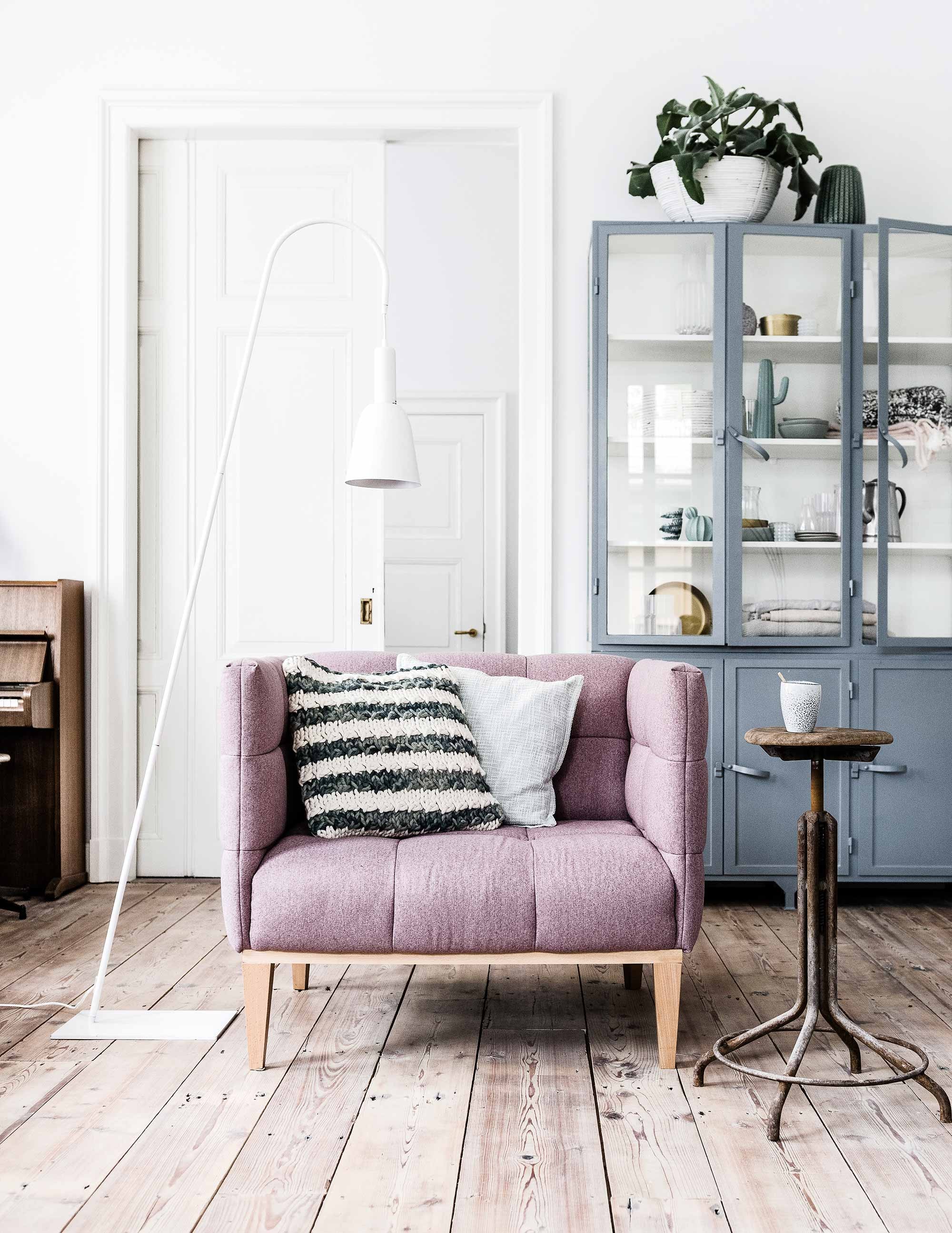 Oudroze fauteuil Svenska,witte vloerlamp Glow van vtwonen, oude witte bamboe schaal, goudkleurige schaaltjes (). Grijze metalen vitrinekast (). Gebreid gestreept kussen, zachtgroen kussen, groene vaas knitted op de kast (). Hoge cactus, lage bolcactus, kopjes per stuk, linnen plaids van By Mölle (). Zwart-wit gebreide deken, roze deken, witte vazen, witte waxinelichthouders (). Oude draaikruk en kopje privébezit.
