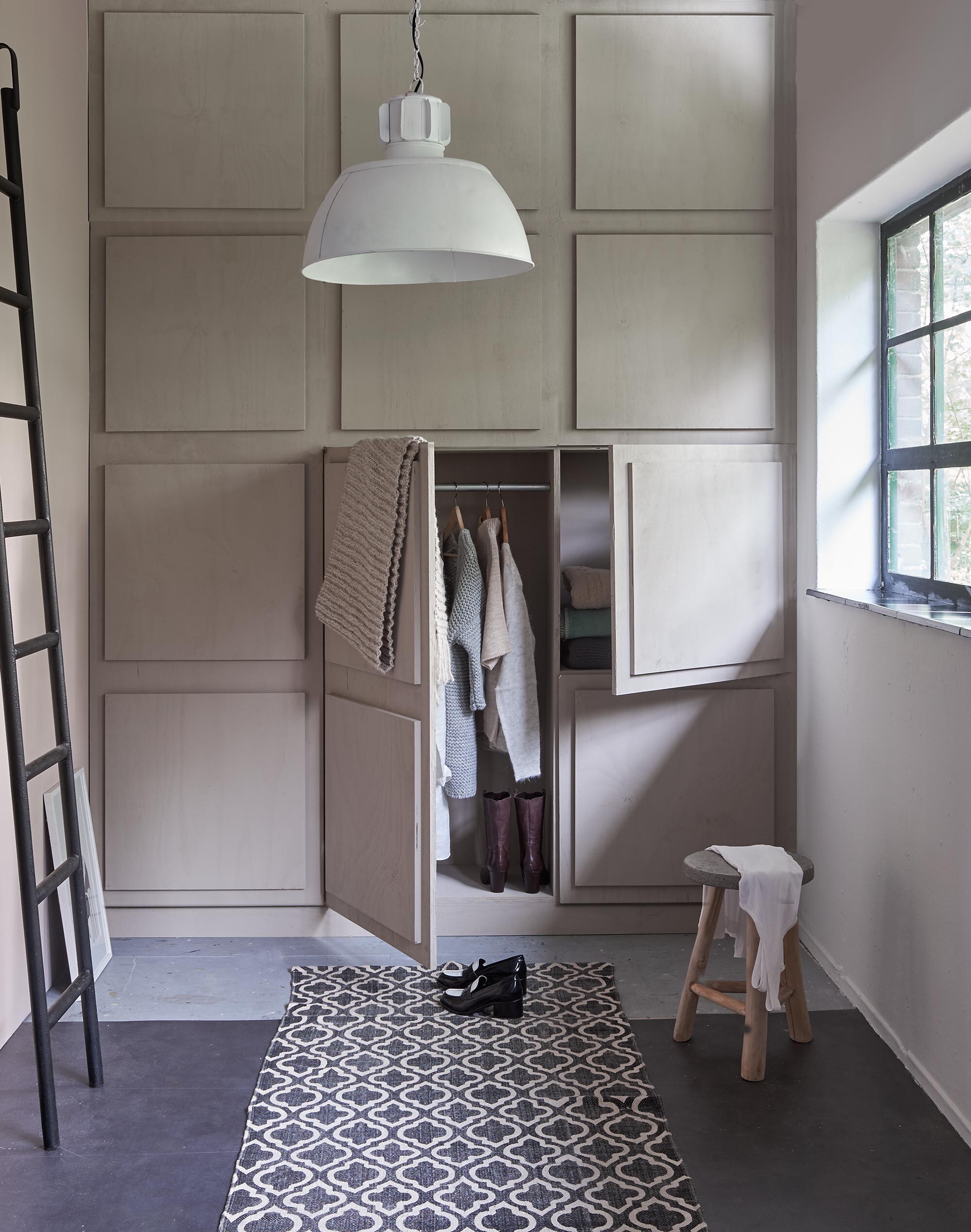 Lamp, trap (De Weldaad). Kruk (Raw Materials). Vloerkleed (Loods 5). Kunstwerk van Petra Lunenberg op de vloer, kleding, grof gebreide shawl over kastdeur (Sukha Amsterdam). Muurverf kleur Cotton van vtwonen by Graham &amp; Brown, kast geverfd met lakverf in Warm Grey 1 liter (vtwonen.nl). Schoenen (Betsy Palmer).