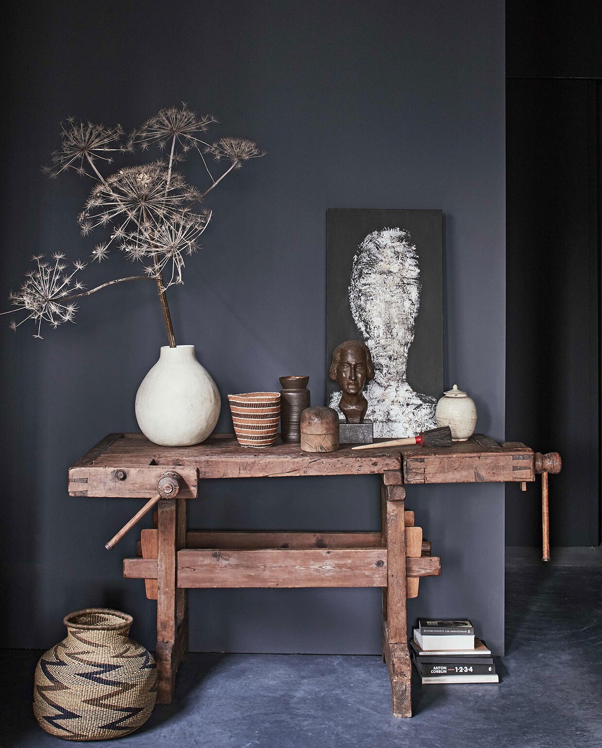 Oude werkbank, hoeden-mal (). Grote vaas van Imperfettolab, vaas met deksel Han Dynasty, schilderij van Mart Visser (). Rieten mand Buhera Gourd Zimbabwe, mand Kenya (). Beeld Componist, bruine vintage vaas (). Kwast (). Boeken privébezit. vtwonen 01-2017 | Fotografie Jeroen van der Spek | Styling Cleo Scheulderman