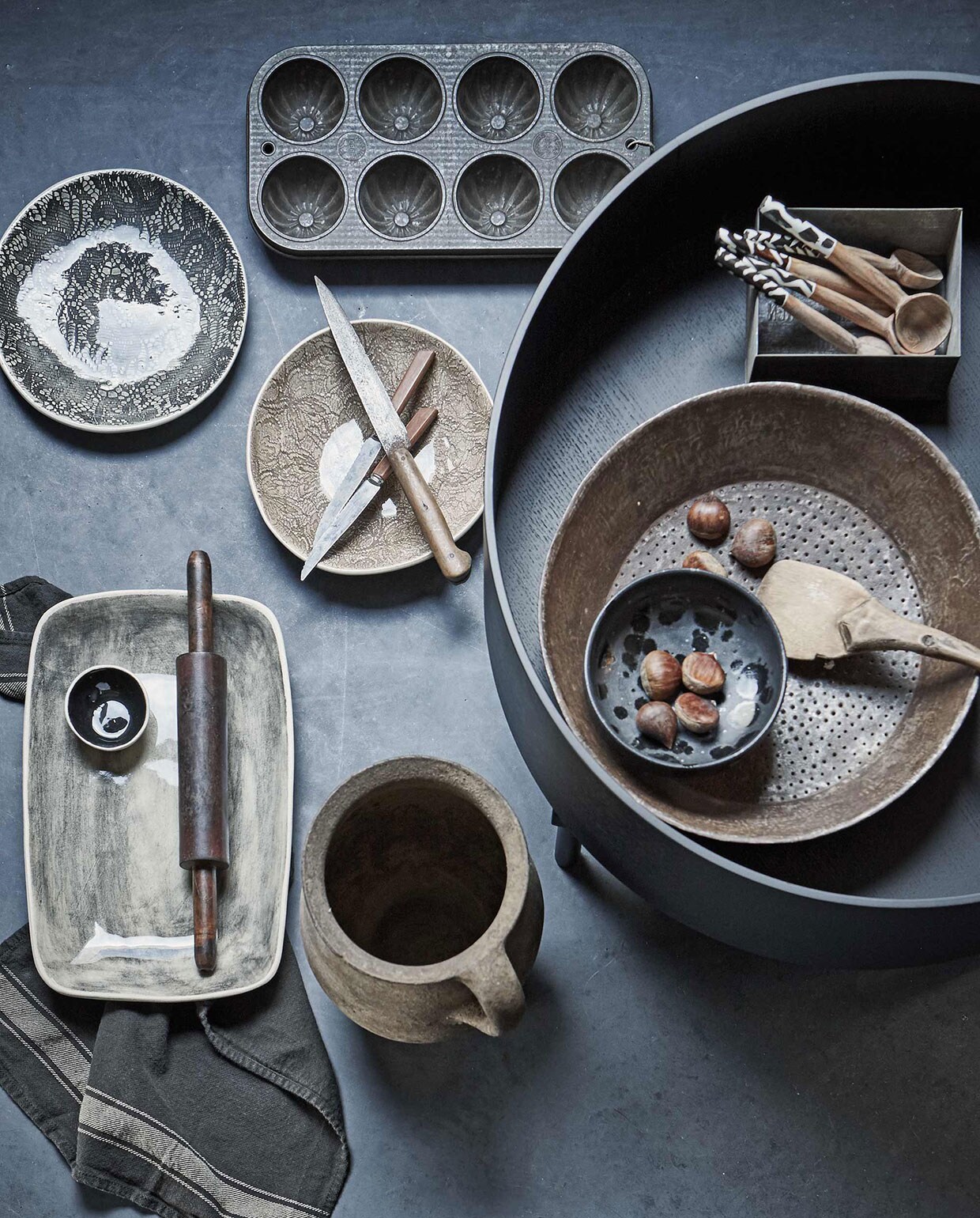 Aardewerken pot, rechthoekig bord van Wonki Ware, ronde borden van Wonki Ware (). Lepels uit Kenia (). Metalen zeef (). Ronde salontafel (). Bakvorm (). Messen klein, groot (). Deegroller (). Zwart schaaltje zwart (). Vierkant bakje van zink (). Platte lepel/spatel (). vtwonen 01-2017 | Fotografie Jeroen van der Spek | Styling Cleo Scheulderman