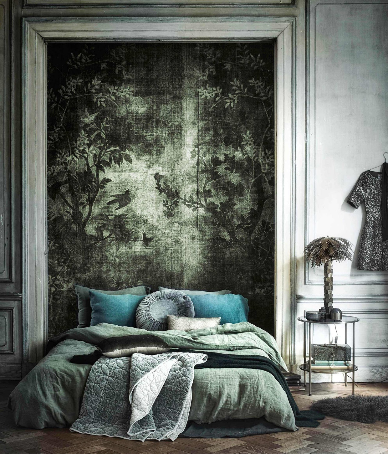 Behang op maat gemaakt WDMN1501 (). Fluwelen quilt, kussen met pailletten (). Rond fluwelen kussen, ronde bijzettafel (). Goudkleurige palmlamp (). Groen oud geldkistje (). Groene wollen deken (). Groen linnen dekbedovertrek 220×240 cm, linnen kussenslopen 50x70cm (). Groene marmeren bal (). Goudkleurig doosje (). Schapenvacht (). Jurk ().