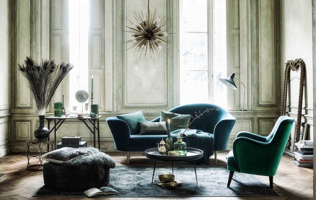 Bank Gubi Grand Piano 220x77x92,5 cm (lxbxh), salontafel Mater Bowl Table XL 75×38 cm (Øxh), vloerlamp Gubi G10 Grossman (). Suède poef, bol op voet met strass stenen vanaf (). Groene Chinese vaas, groene wollen plaid (). Engelse groene vilten klaptafel, goudkleurige kandelaar, groene geldkist, leren hoedendoos (). Antieke goudkleurige spiegellijst (). Groene fluwelen fauteuil, fluwelen kussen (rechts) (). Vloerkleed 180×280 cm, kussen met schildering (). Goudkleurige hanglamp, bijzettafel met cirkels, groen fluwelen kussen (links) (). Groene schapen-vacht, vaas groen-goud, windlicht groen-goud, vaas groen-goud (). Goudkleurige theepot, goudkleurig champagneglas (). Matte  van vtwonen (www.vtwonen.nl). Eiffeltoren (). Kussen met pailletten (). Overig privébezit.