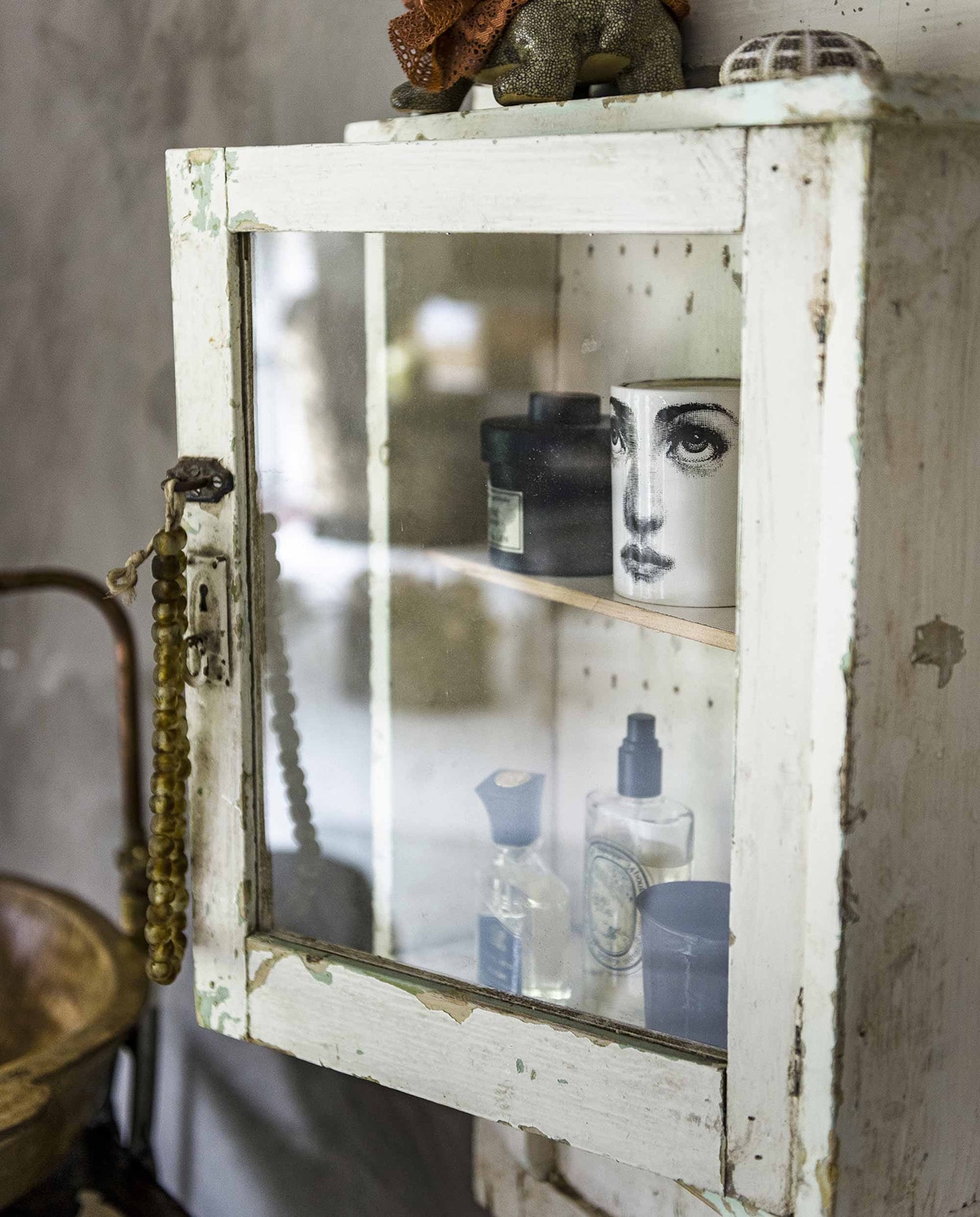 Medicijnkast (). Ketting (). Schildpad-pot (). Schelp (). Beker, flesjes parfum Dyptique vanaf, Creed Royal Oud (). Zwart potje tweedehands. vtwonen 10-2016 | Fotografie Sjoerd Eickmans | Styling Liza Wassenaar