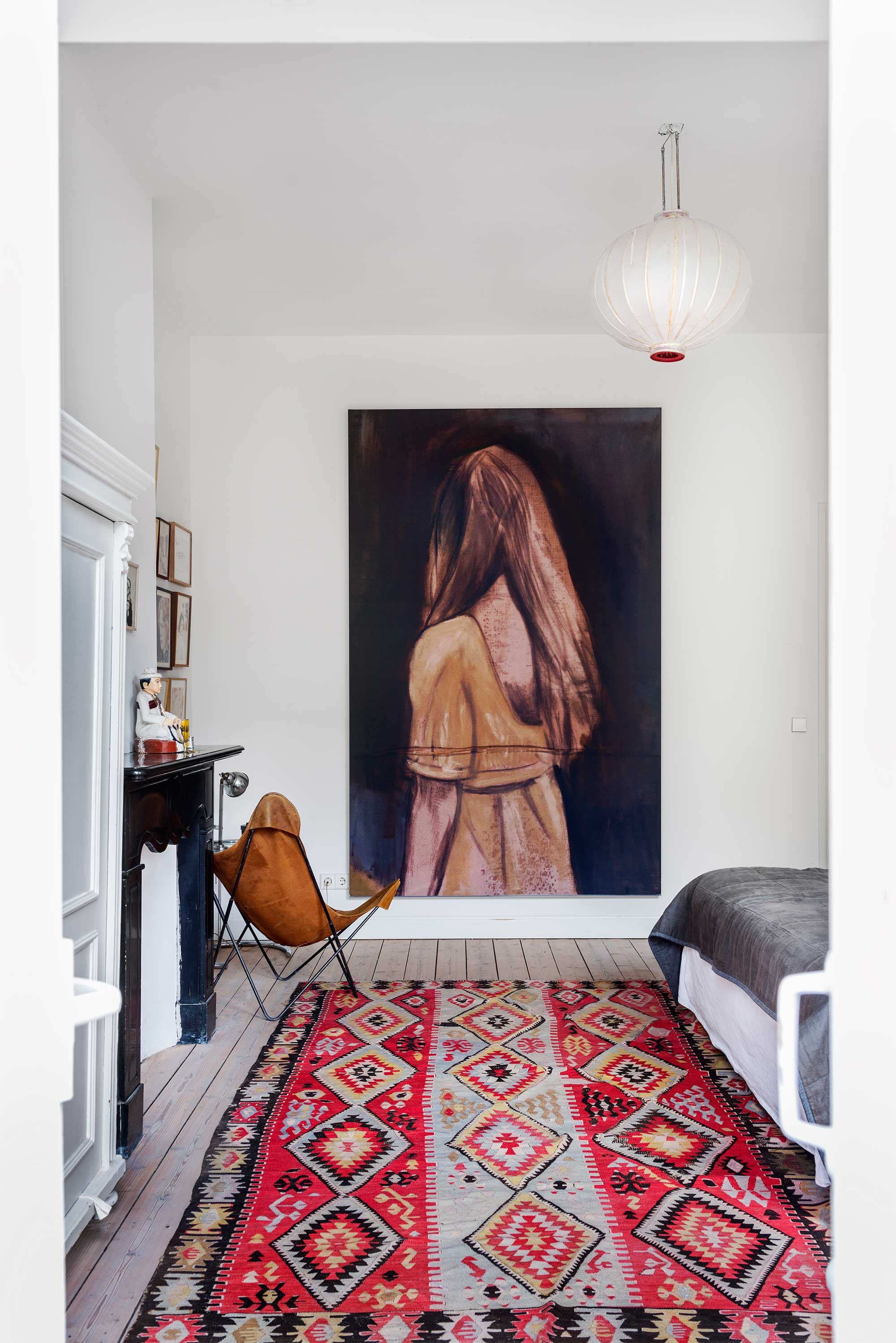 Het schilderij met het meisje Summer van Jasper is bijna drie meter hoog. Bed van Coco-Mat. Vintage Butterfly chair gekocht bij Knoll. Op de grond een vintage Marokkaans kleed. Op de vloer de originele vloerdelen. vtwonen 10-2016 | styling Emmy van Dantzig | fotografie Stan Koolen