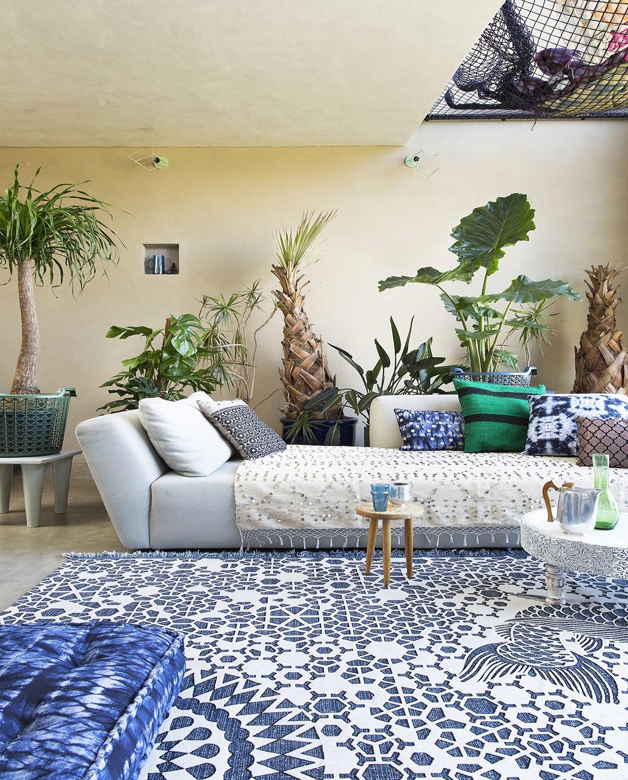 Bank Ittaca in stof Divina, poef (Homestede). Ecru deken met lovertjes, groene karaf, blauwe beker, mand op tafeltje links, karaf in nis (Household Hardware). Kussens v.l.n.r. grijs metallic, zwart ecru Nightflower, Shibori Stripes Oblong (Zenza Home). Kussen groen-zwart gestreept (Household Hardware). Kussen Shibori Sta, kussen Femke Oblong (Zenza Home). Matraskussen op voorgrond Shibori Stripes, wit tafeltje Nomads (Zenza Home). Vloerkleed Milek (Design 020). Theepot (Neef Louis). Planten (www.chicplants.com). Overig privébezit. vtwonen 08-2016 | Fotografie Jansje Klazinga | Styling Frans Uyterlinde