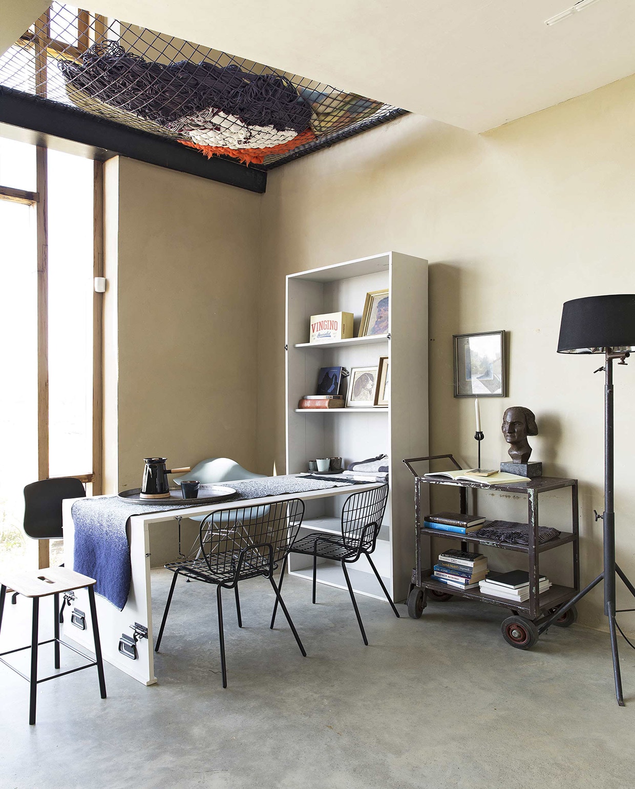 Vloer van gevlinderd beton per m² prijs op aanvraag (House of Bouw). Kast met uitklaptafel (Combitex). Krukje Adam Stool, stoel WM String Chair van Menu, stoel About a Chair AAC10 van Hay kunststof zwart (The Frozen Fountain). Stoel DAR van Eames (Design 020). Tafelloper MOD van Mae Engelgeer, Cowboy Coffee Kettle van Umbra Shift (Restored). Donkerblauwe beker, borden, bekers (Store Without a Home). Dienblad, doeken, hanglamp Cradle Bottle, kaarsenstandaard (Raw Materials). Staande metalen schemerlamp Black Hole Light (Nicky Zwaan). Metalen vintage trolley, buste (Neef Louis). Overig privébezit. vtwonen 08-2016 | Fotografie Jansje Klazinga | Styling Frans Uyterlinde
