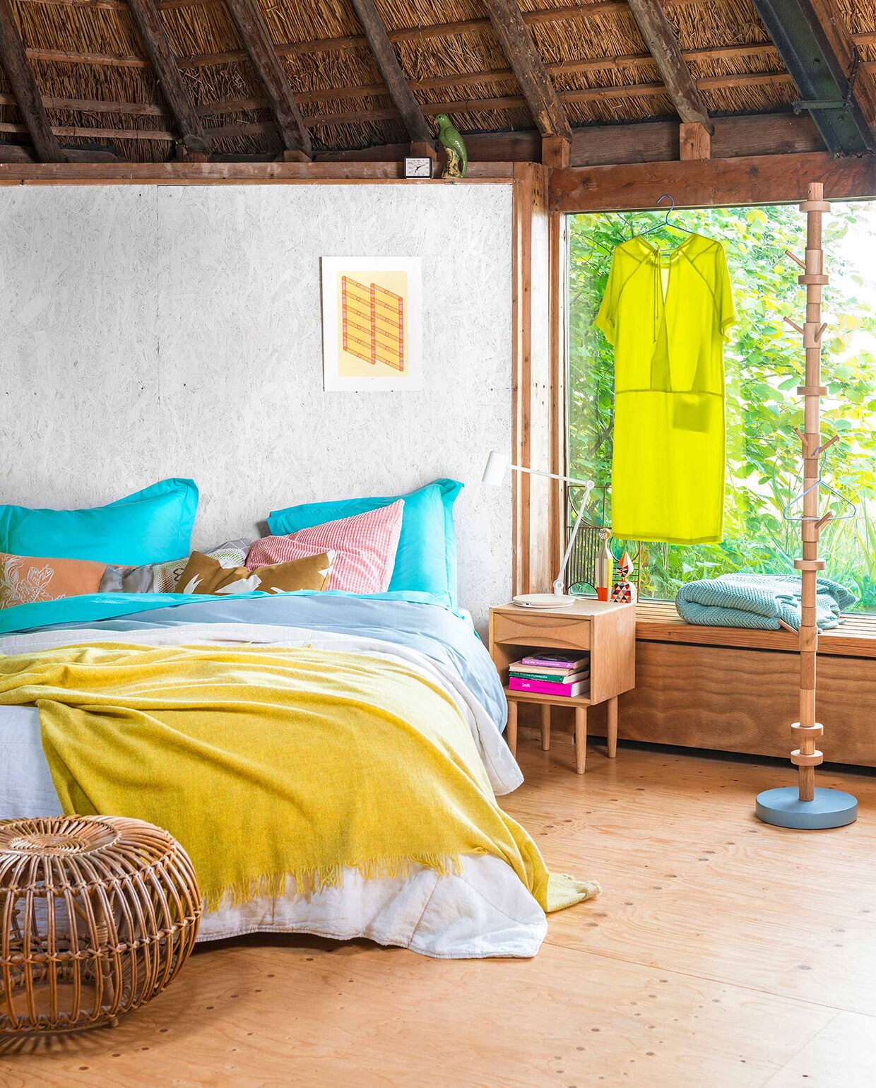 Illustratie Risoprint ontworpen door Sigrid Calon. Jurkje Bem. Kapstok Stack. Dekbedovertrek van perkalkatoen, kussenhoes. Kussen print lang.  met print,  Outline Wall Smokes Oak (Ferm Living). Sprei Oso sand, gele plaid Fly Piccalilly Melee.  Wooden Doll no. 12 en no. 14 ontworpen door Alexander Girard (Vitra). Nachtkastje ontworpen door Arne Vodder. Plaid Zigzag mint. Rotan poef. Roze kussen en lamp privébezit. vtwonen 08-2016 | fotografie Stan Koolen | styling Kamer 465 | bloemstyling Saskia de Valk