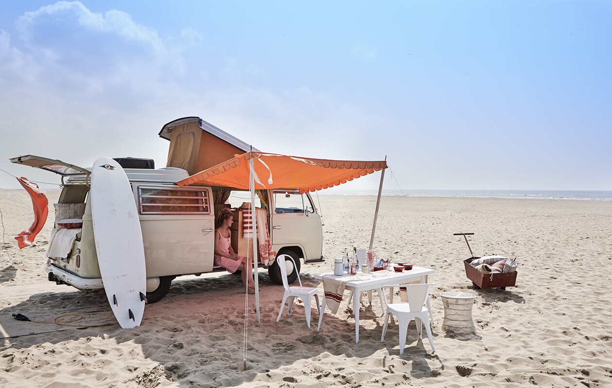 Tafel Tolix, stoel zonder leuning Tolix Chaise A, stoel met leuning Tolix Chaise A56, rode emaillen kommen (). Jurk, rood-witte rietjes (). Witte emaillen kan met beker (). Oude linnen doek met rode streep, rode trekkar (). Fles van Nicolas Vahé (). Schalen Fish &amp; Fish van Paola Navone (). Doek met rood dessin, kussentje (). Gestreepte doek (). Witte kruk, patchwork kussen (). Hamamdoek (). Linnen sprei Louisiana Stripe (). Hoed (). Overig privébezit. VW Westfalia te huur via . vtwonen 08-2016 | Fotografie Jeroen van der Spek | Styling Cleo Scheulderman