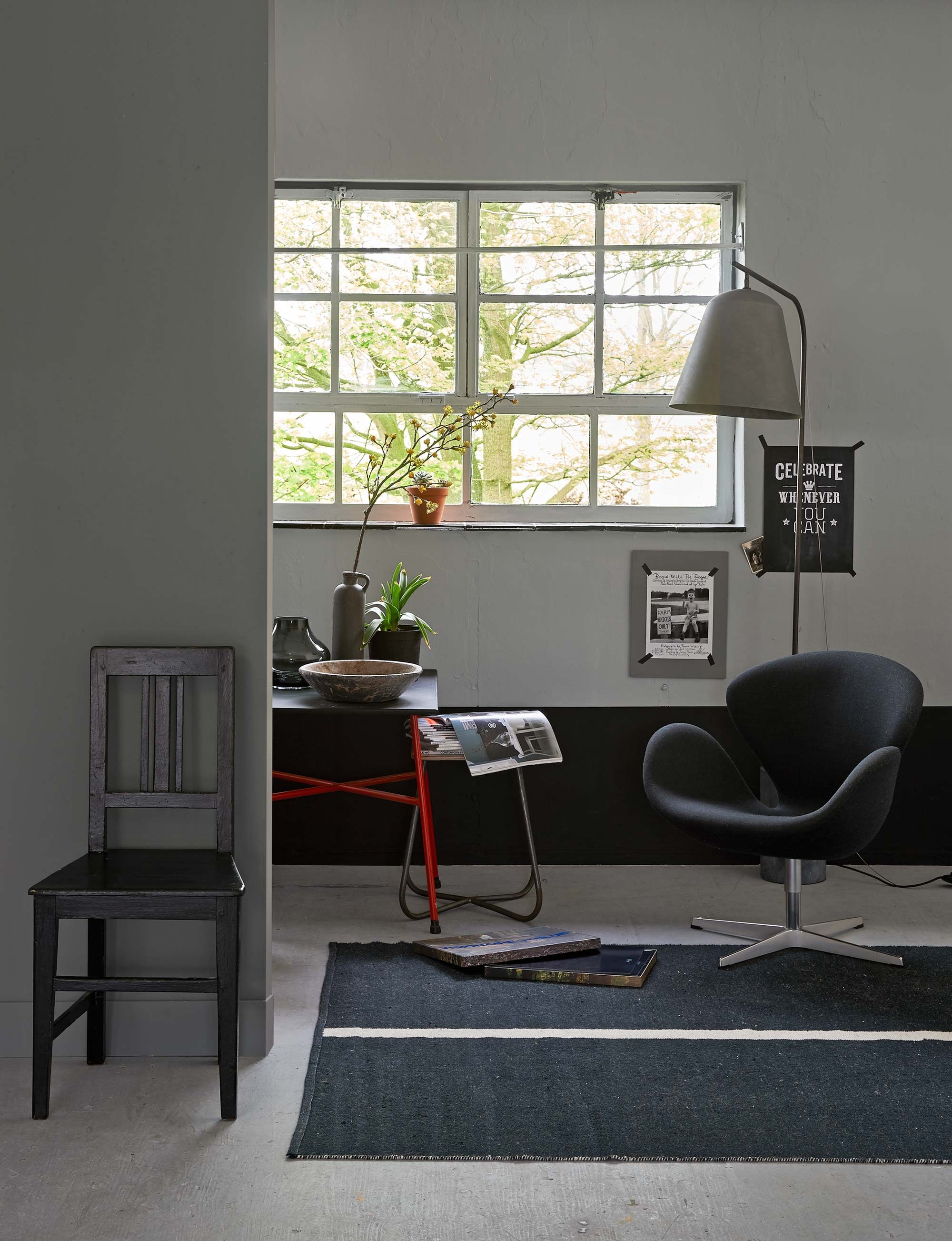 Verfkleur achter stoel: zinc, verfkleur bij raam: iron, verfkleur rand: pitch black. Lamp (The Frozen Fountain). Fauteuil, kruk (Neef Louis). Tafel (van Dijk &amp; Ko). Glazen vaas, betonnen kruik (Loods 5). Vloerkleed (Het Kabinet). Houten stoel (Old Basics). Overig privébezit. vtwonen