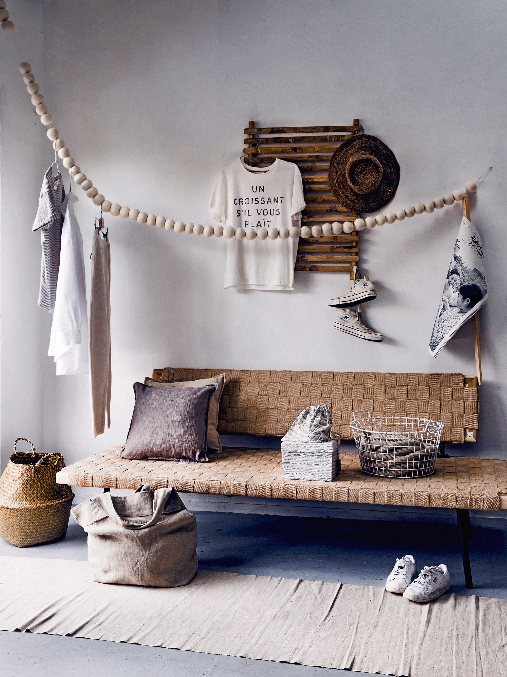 Slinger vilten bollen lengte 300 cm, hoed, papieren opbergdoos, zakje met notebook 21×14,5 cm, linnen tas, touw per meter (Sukha Amsterdam). Bamboe rek 60×40 cm (Anders Nog Iets). Bank Sinnerlig 86x192x73 (bxlxh) (Ikea). Kussens (Zusss). Mand (Xenos). Linnen op rol als vloerkleed per meter (Van Dijk &amp; Ko). T-shirt un croissant, overige kleding (Sissy-Boy). Converse All Stars (Zalando). Krant aan stok privébezit.