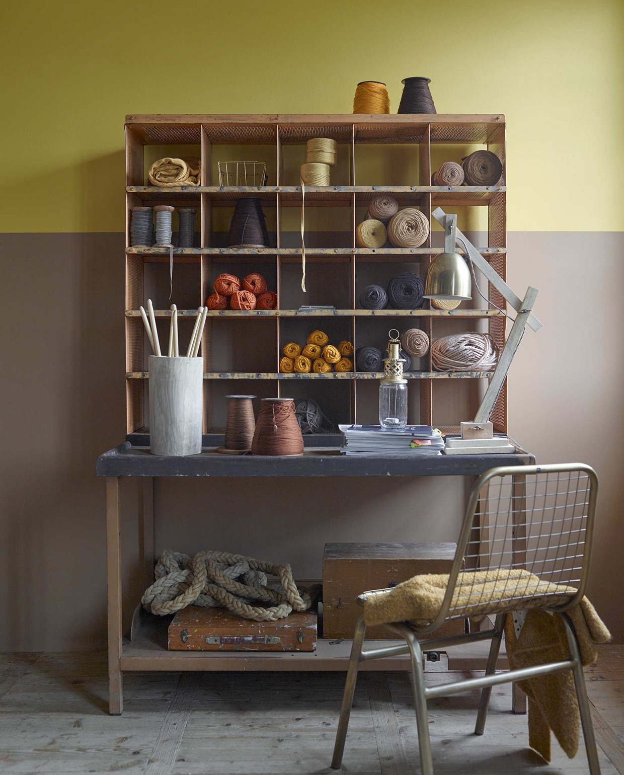 Muurverf (kalkmat) in de kleuren Real Mustard en Real Brown uit de Pure collectie, (Flexa). Postkast, grote klos garen, houten kisten, klimtouw (Neef Louis). Diverse bollen wol per bol, brei- en haaknaalden (Nijhof). Houten pot, lantaarn (Household Hardware). Goudkleurige draadstoel, tafellamp kap, mandje, okerkleurige plaid van Madam Stoltz (www.deens.nl). Okergeel vest (Sissy-Boy). vtwonen 01-2016 | Fotografie Tjitske van Leeuwen | Styling Marianne Luning