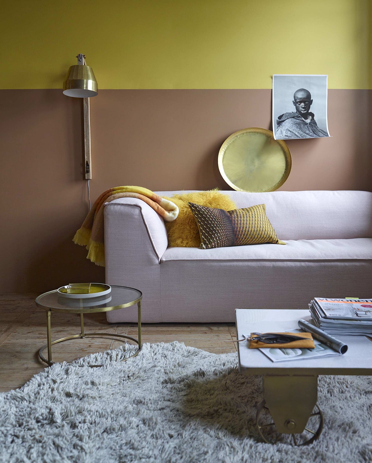 Muurverf in de kleuren Real Mustard en Real Brown uit de Flexa Pure collectie (Flexa). Bank nr. 6905 van Scholten &amp; Baijings, bekleding Kvadrat linnen/wol (Gelderland). Industriële salontafel met groen marmeren blad, ronde bijzettafel met glasplaat, okerkleurig bord van Madam Stoltz, glazen opbergbakje van Madam Stoltz, wandlamp van Madam Stoltz (www.deens.nl). Kussens geel-zwart, geel etui (Friday Next). Vloerkleed wol Bearskin 190×270 cm (Storebror). Okergeel schapenvachtkussen, gouden schaal (Nijhof). Plaid Desert Stripe (Malagoon). Poster uit Marrakech (maisondelaphotographie.ma). vtwonen 01-2016 | Fotografie Tjitske van Leeuwen | Styling Marianne Luning