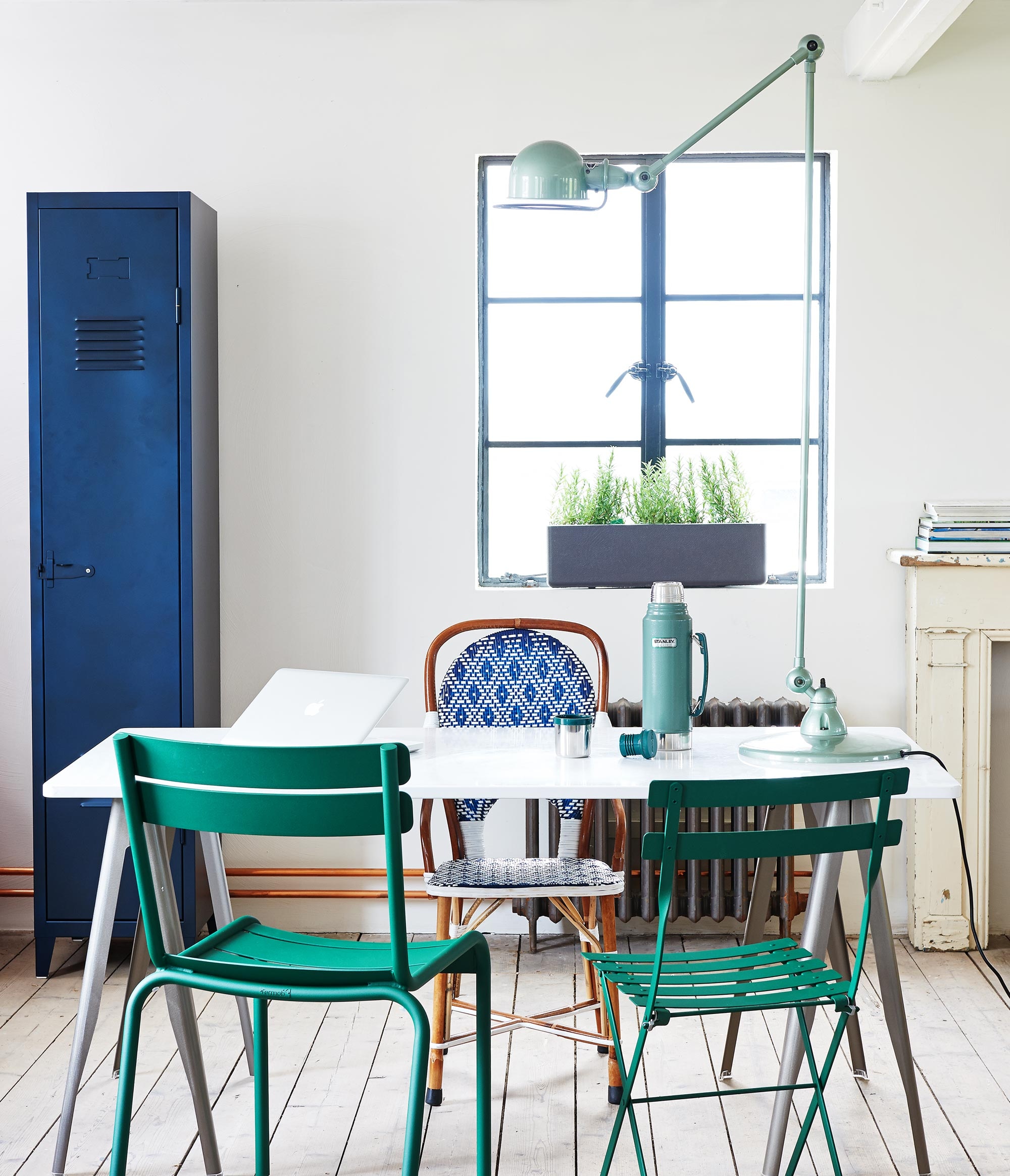 Lockerkast van Tolix, eettafel met losse schragen van Tolix 200×80 cm (lxbxh), plantenbak Balconia van Eternit 80×20 cm (Extra Vert). Jieldé vloerlamp (themanor.nl). Groene Luxembourg-stoel van Fermob links, bistrostoel van Fermob (Extra Vert). Rieten stoel Armande (Ha50). Thermoskan Stanley (Urbans and Indians). In de plantenbak zit rozemarijn.