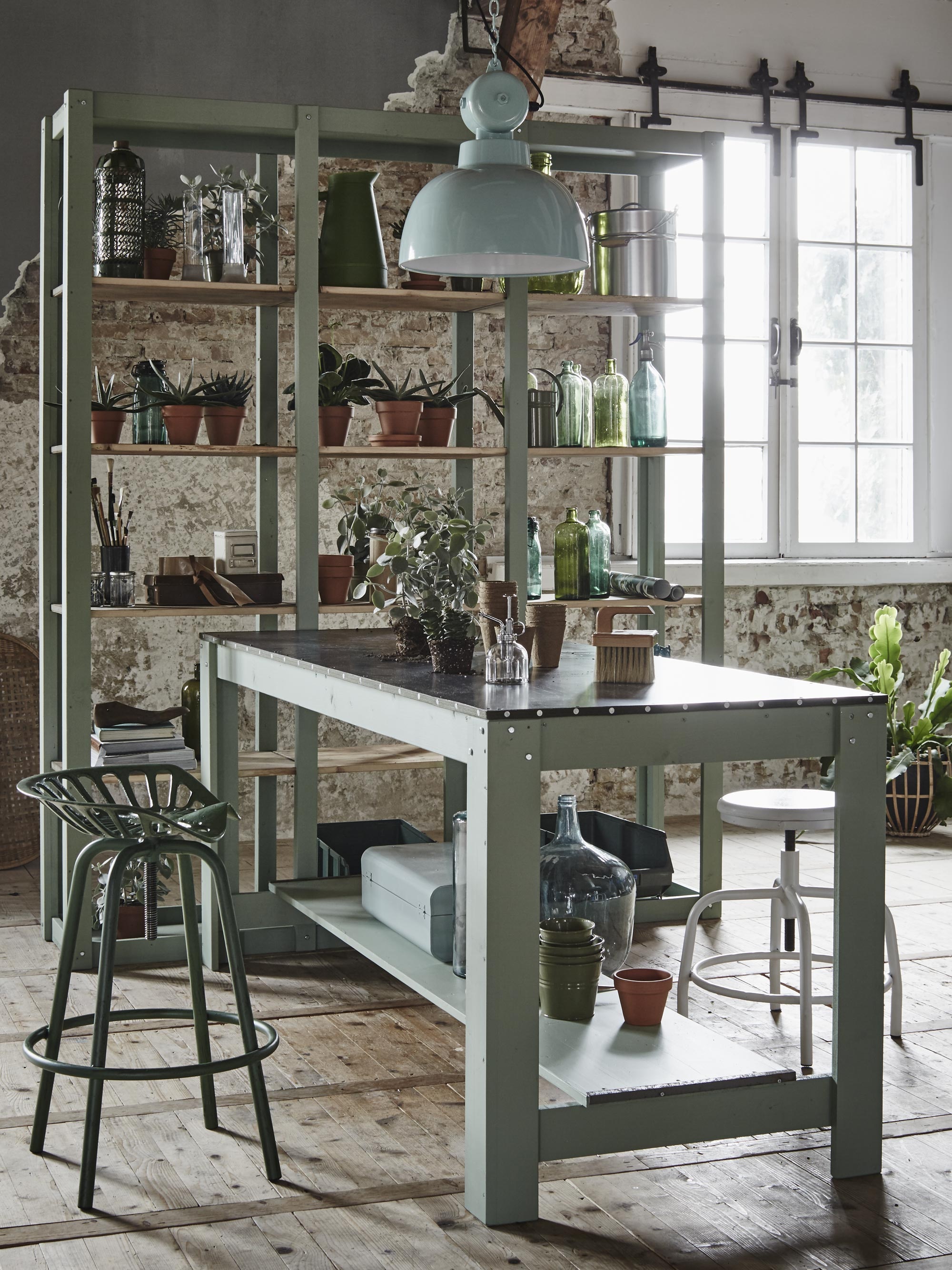 Tafel vanaf (). Lamp Factory medium (). Stellingkast vanaf (). Planten: op tafel Kalanchoë met vergrijsd groene bladeren en in de kast Gasteria (). Bovenste plank in de kast: thermosfles, maatbekers, groene kan (). Zinken bloempotten, metalen emmer met deksel (). Tweede en derde plank en op en onder tafel: groene vazen en flessen (). Gieter, terracotta potten, olijfgroene bloempotjes (). Vierde plank:  van vtwonen (vtwonen.nl).  van Esschert Design,  uit de vtwonen collectie, onder tafel  (vtwonen.nl). Grote vaas naast de tafel (). Overig is privébezit.