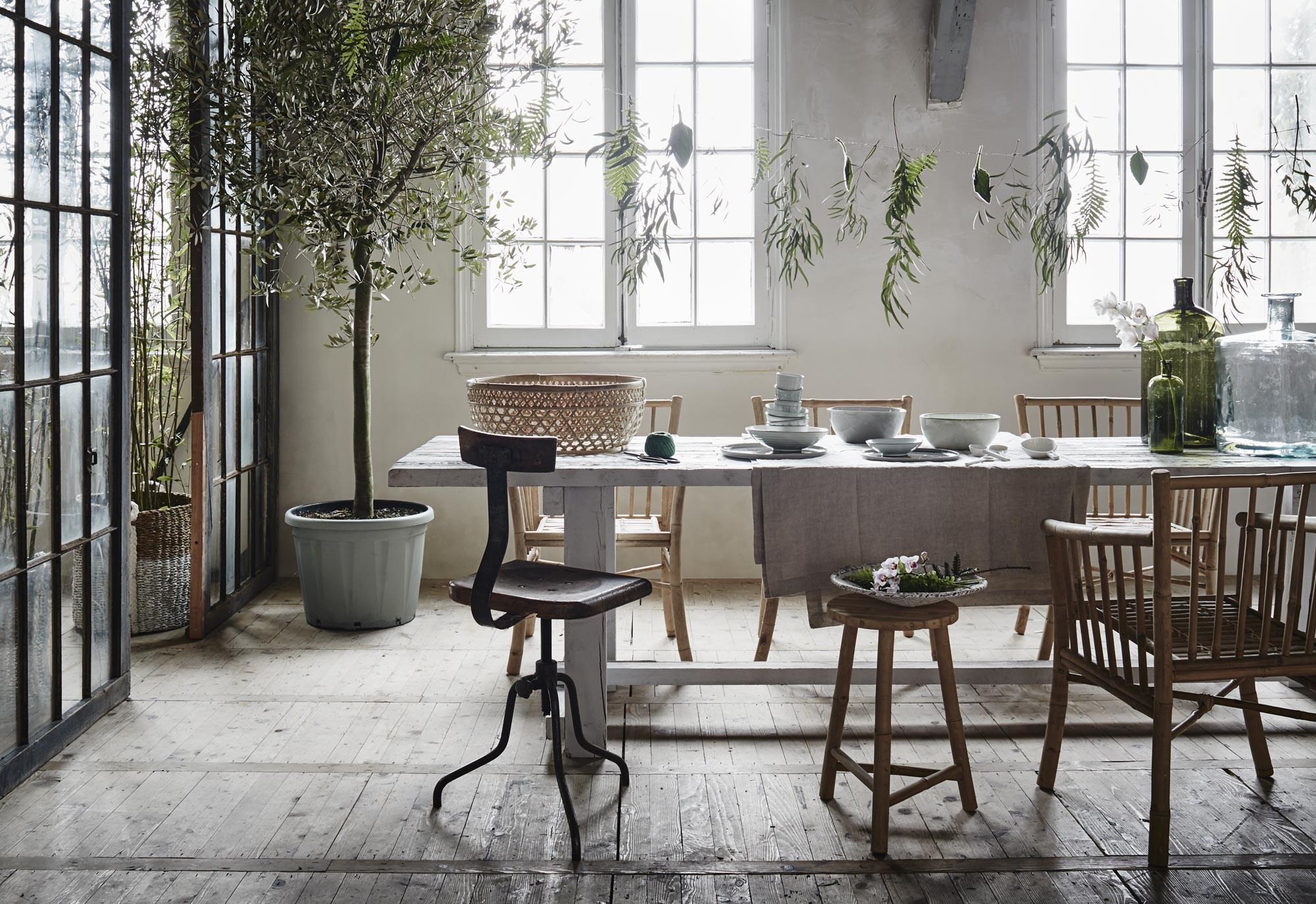 Eettafel, 300×70 cm (). Bamboe kruk van Tine K Home, bamboe eetkamerstoelen (). Metalen atelierkruk Pleven ().  van linnen (Sissy-Boy). Grote mand en witte rieten schaal op kruk (). Bol garen (). Schalen vanaf, porseleinen lepels (). Dinerborden en kopjes (). Grote groene vaas (). Kleine vaas ().  Leonardo (vtwonen.nl).