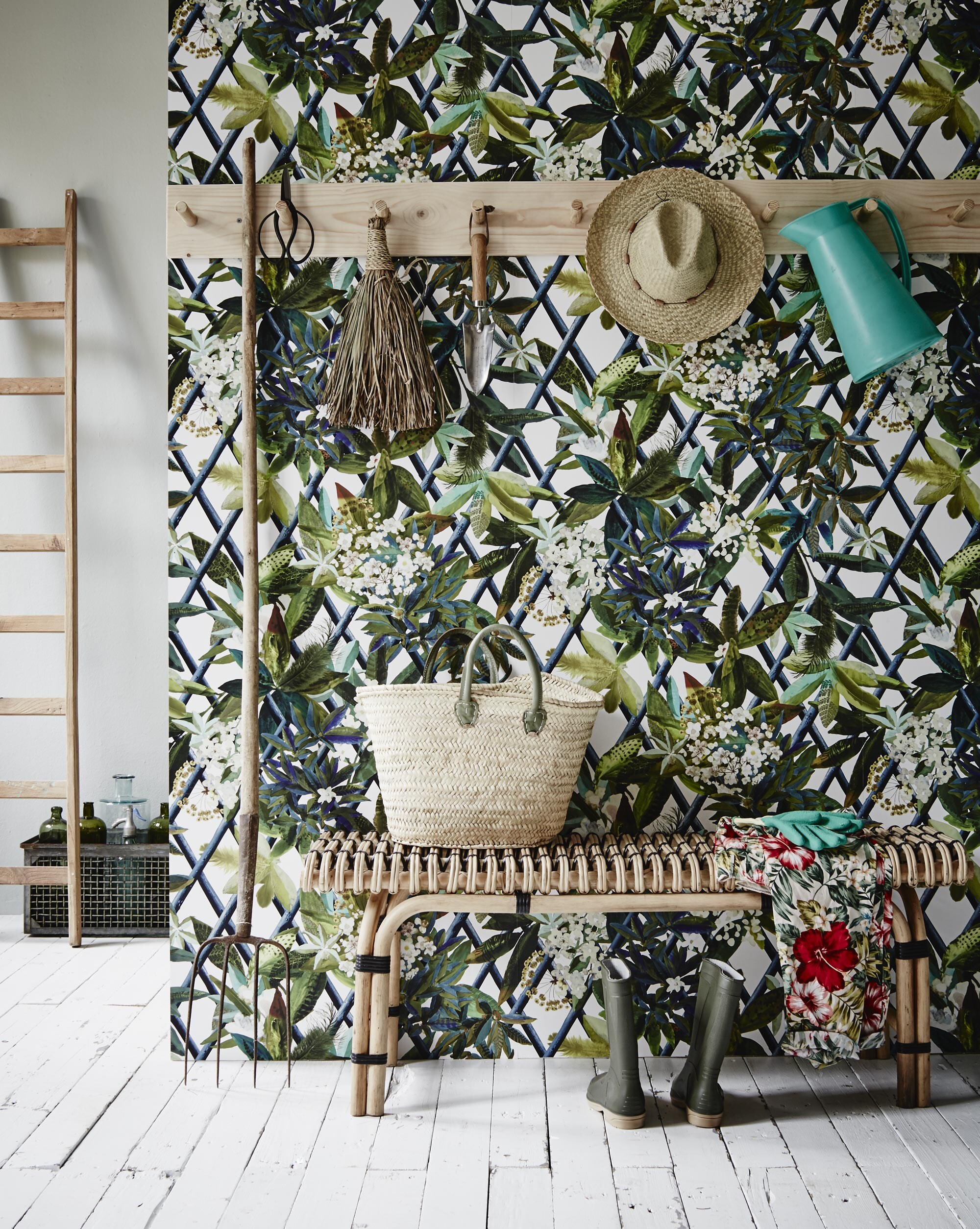 Behang Canopy Saphir PCL661/07 van Christian Lacroix per rol van 68,5 cm breed en 10 meter lang (). Kapstok (). Aan de kapstok: bonsaischaar, schepje (). Handbezem, hoed (). Kan ().  (HK Living). Erop: plukmand, tuinhandschoenen (). Broek (). Regenlaarzen vanaf (). Ladder (). Krat Vaja met flessen (). Witte vloer ().