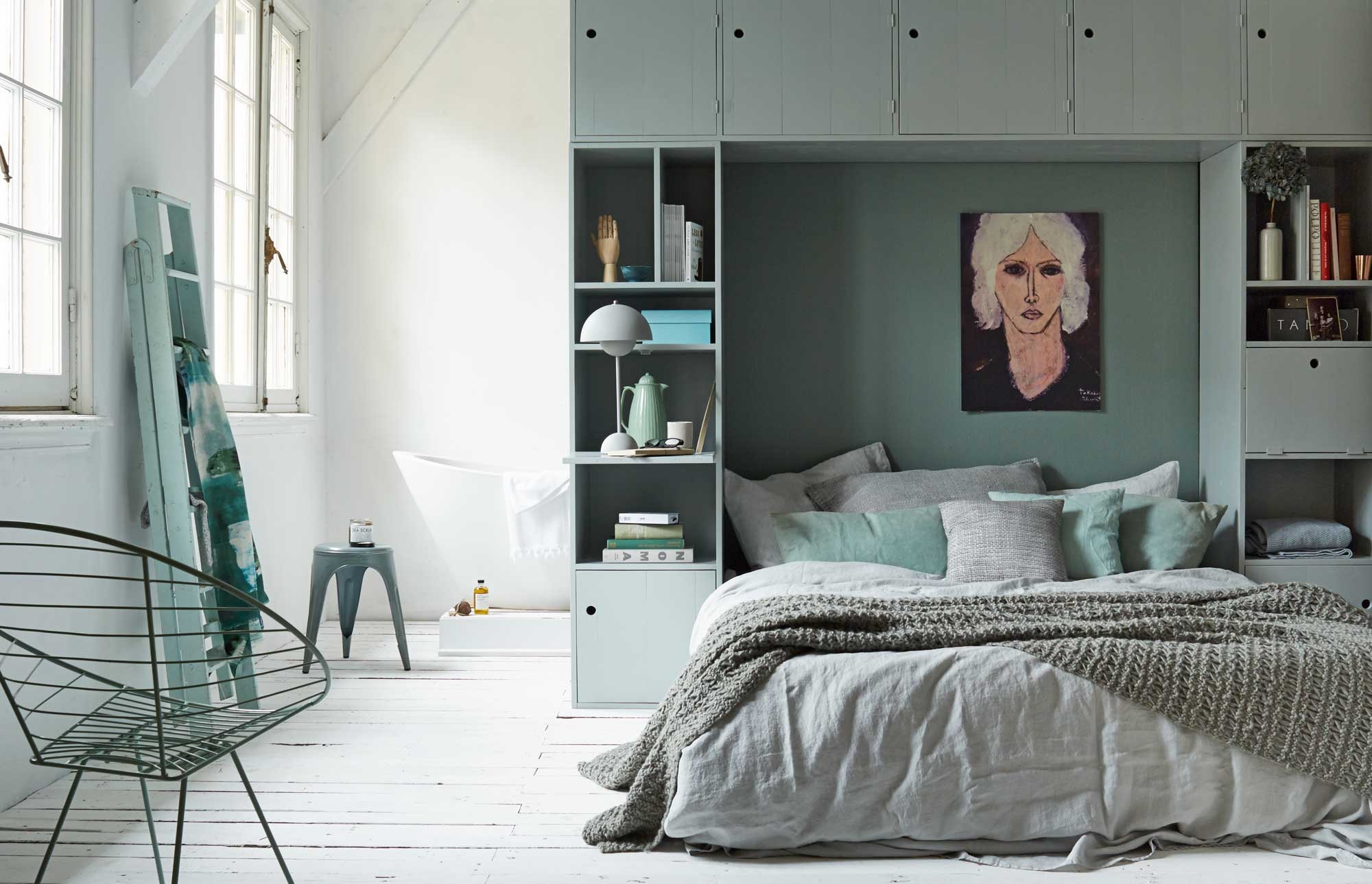 Kastombouw,- en trap, gebreide sokken (Combitex). Grijs linnen dekbedovertrek van la Fabbrica del Lino (Fich Home). Mintgroene kussens in canvas en linnen, stoel Happy (Nordal). Thermoskan, blauwe kartonnen opbergdoos in set van 5 (vtwonen.nl). Grijze linnen kussens 60×60 cm per stuk (By Mölle). Gebreide wollen sprei, sea scrub en badolie (Sukha Amsterdam). Lamp, hand (Friday Next). Donkerblauw bakje, keramieken beker, koperen beker (Restored). Sjaal (Jan). Bad Vasche van Sign (Ton Scholten). Witte handdoek (Nooo Sugar). Metalen kruk (Madam Stoltz). Dekbed Mysa 220×240 cm en hoofdkussens Gosa Raps (Ikea). Afbeelding op karton geprint (Repros). Muurverf Castle Gray van Farrow &amp; Ball , lakverf kast Light Blue van Farrow &amp; Ball 0,75 liter (De Ru). Boeken en vaasje privébezit. vtwonen 11-2014 | styling Cleo Scheulderman | fotografie Alexander van Berge