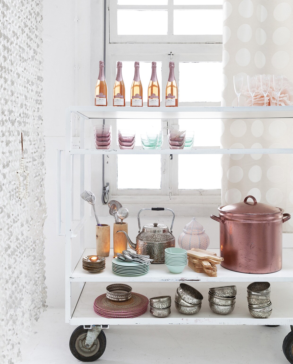 Kar € 225,- (Combitex). Boven: brut rosé Lindemans € 9,99 (Albert Heijn). Champagne-glazen Svalka per 6 stuks € 4,49 (Ikea). Pompon per set van 3 € 17,50 (Engelpunt). Glazen serveerkommetjes Skoja € 1,49 (Ikea). Houten vijzel € 49,-, erin lepels set van 12 € 10,-, schoteltjes gouden rand € 1,65, schaaltjes per stuk € 17,- (Household Hardware). Antieke ketel privébezit. Groene borden en schaaltjes uit 12-delig servies Strosa € 12,95 (Ikea). Lantaarn € 87,- (Zenza). Houten plankjes per stuk € 2,99 (Ikea). Met koperverf beschilderde pan € 35,- (Combitex). Placemats € 3,49 (Ikea). Schaaltjes € 17,- (Household Hardware). Camouflagenet wit per meter € 8,95 (Combitex). vtwonen 01-2014 | Fotografie Jansje Klazinga | Styling Frans Uyterlinde