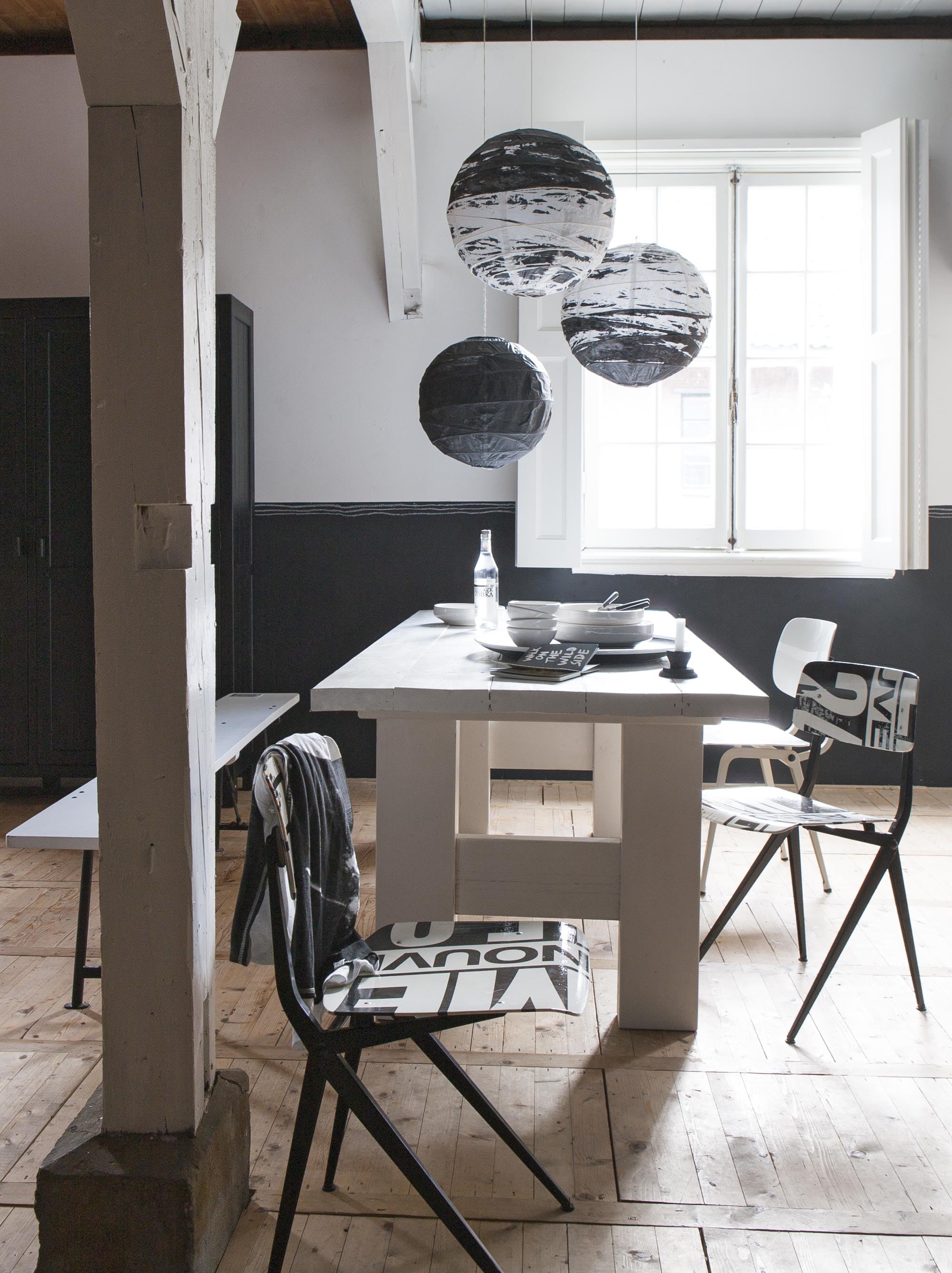 Tafel (Combitex). Revolt stoel wit (Anno). Stoelen bekleed met wildplakposters uit Parijs en afgewerkt met toplaag (Project 99). Kast (HK Living). Bankje (Nijhof). Bollampen (Ikea). Servies (Household Hardware). Kandelaar (Nijhof). Schaal (Het Kabinet).