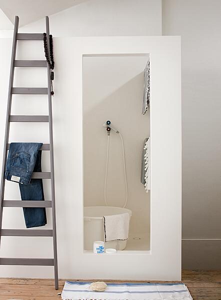 beeld vtwonen In deze badkamer is van mdf een rechthoekige unit gebouwd meet twee douches erin. De hele binnenkant is waterdicht gemaakt met polyester met een witte topcoating. In de rechterwand zitten stangen om de badlakens aan op te hangen. De ladder is een blikvanger in de ruimte die ook ruimte biedt aan handdoeken en kleding.