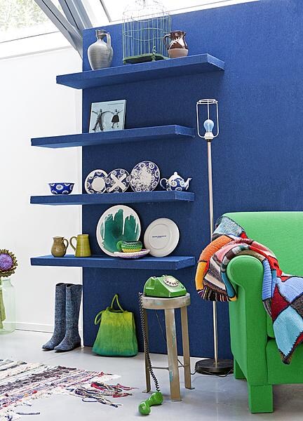 beeld vtwonen Planken kun je ook bekleden. Wij gebruikten een stoere jeansblauwe stof en zetten deze vast met nietjes.  Het voordeel van bekleden is dat je de planken dan gerust een stukje kunt laten uitsteken aan de zijkant van een muur, omdat de achterkant ook mooi is. Het effect is speels als je niet alle planken even ver laat uitsteken. Je hebt wel te maken met het ophangsysteem, dus er zijn grenzen.