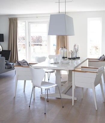 beeld vtwonen Bij de witte tafel van Piet Hein Eek staat een vlinderstoel van Arne Jacobsen. De lamp is van Moooi. Samen vormen alle meubels een mooi rustig geheel. Ideaal voor mensen die een hectisch leven leiden. Fotografie Simone de Geus.