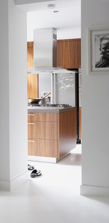 beeld vtwonen Door de witte basis van het huis, springt de houtkleurige keuken echt in het oog. Hoewel de keuken van fineer is, lijkt het net echt hout. Mooi punt om op te besparen als de bodem van de portemonnee in zicht komt. Fotografie Simone de Geus.