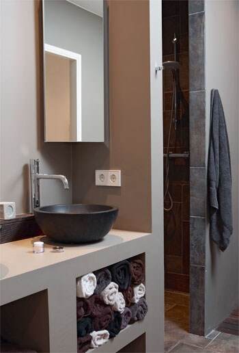beeld vtwonen In deze moderne badkamer zijn verschillende natuurlijke tinten gebruikt. Doordat alle kleuren rustig zijn, is het een mooi sereen geheel. Fotografie Simone de Geus.