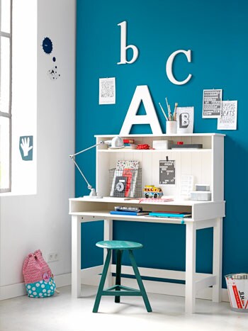beeld vtwonen Ook als er nog geen huiswerk gemaakt moet worden, is deze werktafel ideaal om aan te tekenen en de eerste woordjes op papier te zetten. Grappige details zijn de grote houten letters. Dit alles is uit de vtwonen juniorcollectie. De muur is geverfd in de kleur Azuurst van Flexa vtwonen kleuren. Het krukje is van Combitex. Fotografie Fotolemaire.nl.