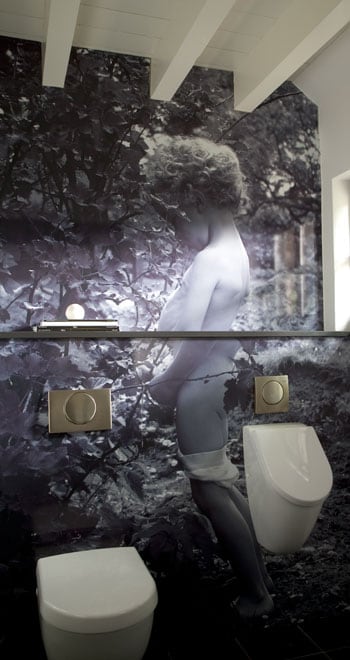 beeld vtwonen Van het kleinste kamertje in huis kan je nog best wat leuks maken. Hier is gekozen voor een ludiek fotobehang. Naast het toilet hangt een urinoir voor de mannen. Fotografie Bieke Claessens.