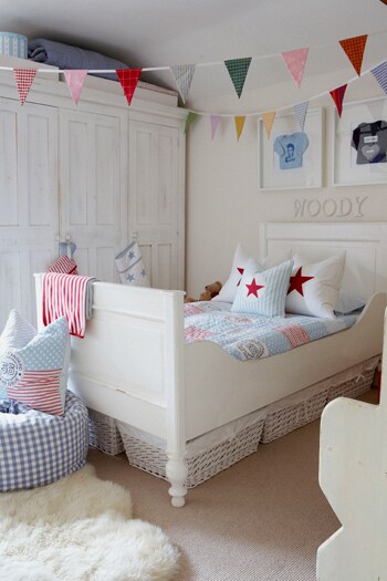 beeld vtwonen In deze vrolijke kinderkamer is het elke dag feest! De kleuren van de vrolijke vlaggetjes komen terug in het dekbed, de kussens en de poef. De opbergmanden onder het bed zijn handig voor losslingerend speelgoed. Fotografie Brent Darby/ Narratives.