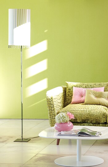 beeld vtwonen Het gebruik van frisse groene en roze kleuren geeft meteen een zomers gevoel in huis. De lampenkap is hier bekleed met stof Chawton. De tweezitsbank Hayward is bekleed met Nabucco. De kussens op de bank zijn gemaakt van Chinon-zijde. Het behang is de Tsuga van Designers Guild.