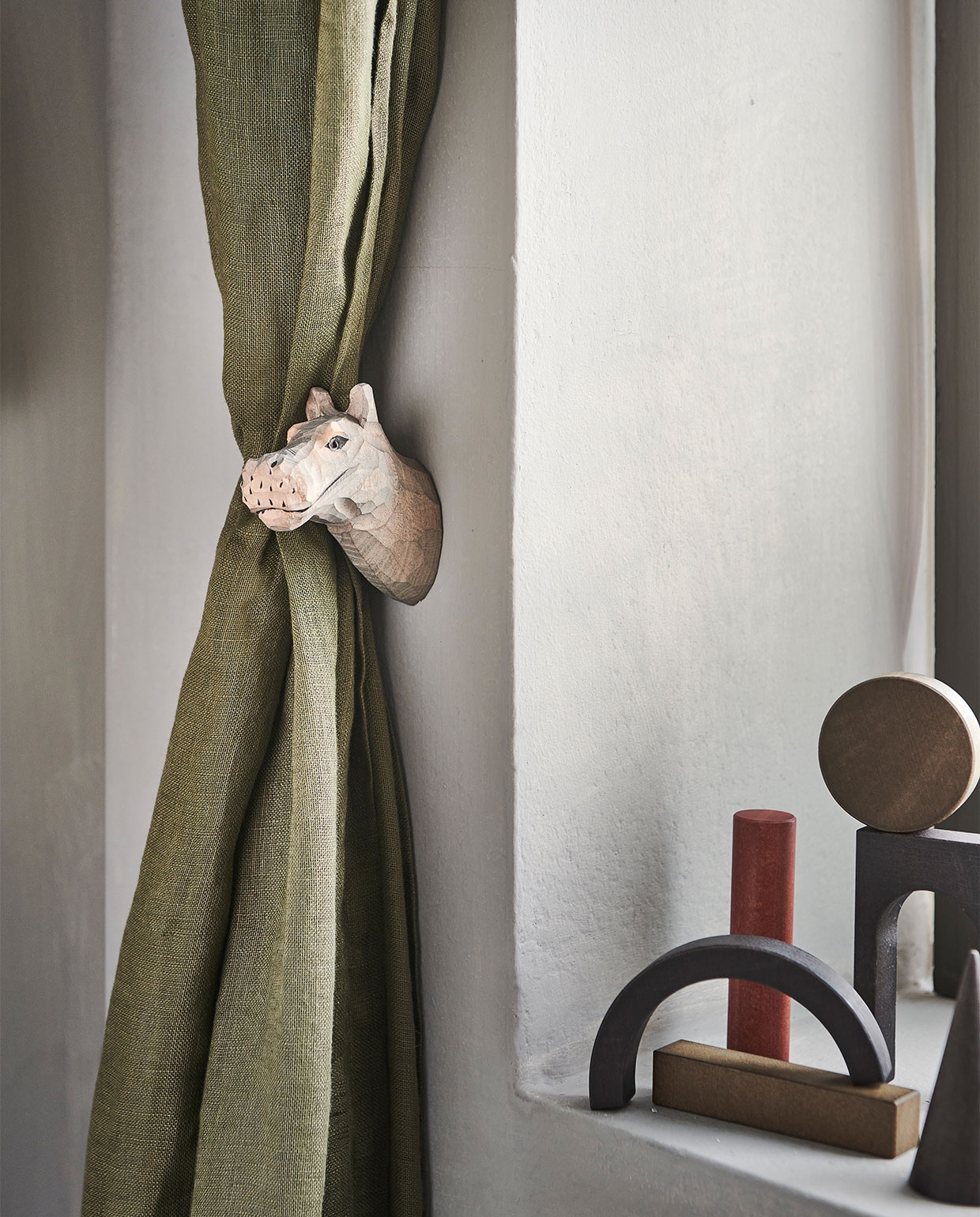 Linnen gordijn in donker kakigroen, set van 2 € 69,99. Haak nijlpaard van Ferm Living. Overig herkomst onbekend JA | vtwonen bijlage 13-2021 | styling Kim van Rossenberg  | fotografie Sjoerd Eickmans